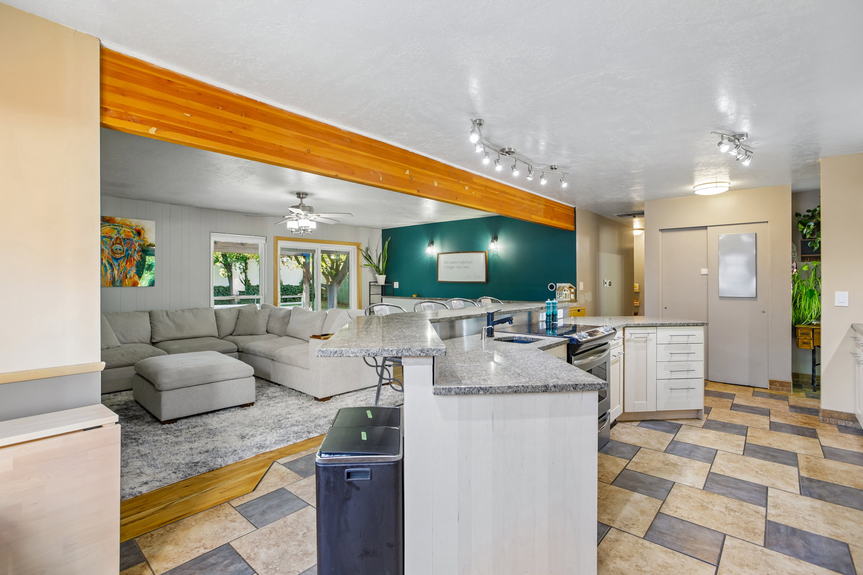 Kitchen featuring granite countertops, white cabinetry, a built-in range, and a patterned tile floor