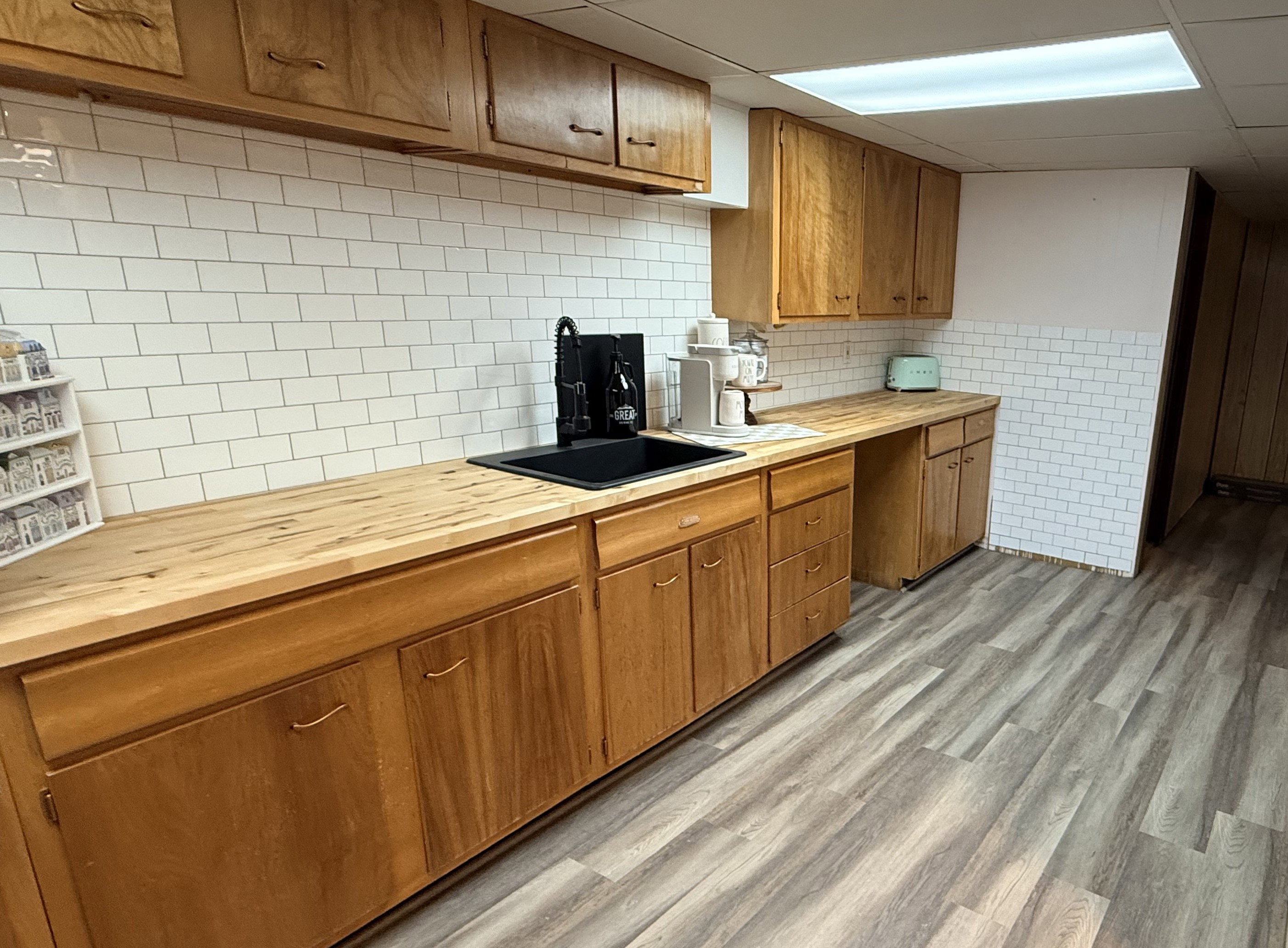 Full-height subway tile backsplash complementing wood-finish countertops and cabinetry
