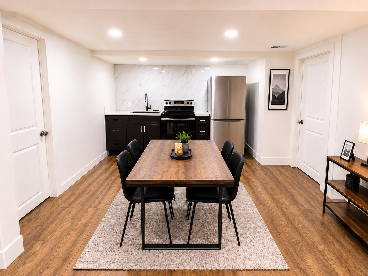 Open-concept kitchen and dining area featuring wood-finish flooring, recessed lighting, and white walls