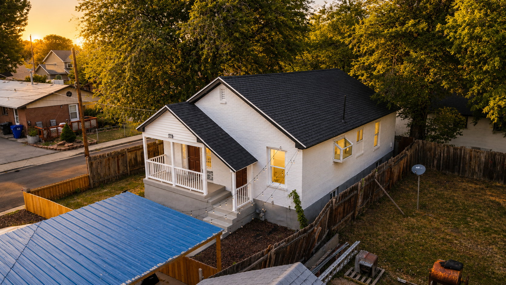 White exterior with a dark shingle roof and a covered porch