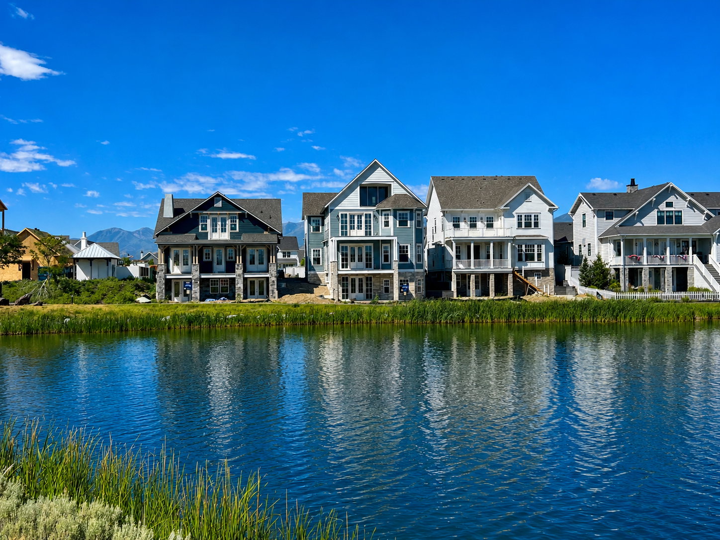 Waterfront property featuring multiple residences with varied architectural styles, each presenting distinct exterior finishes