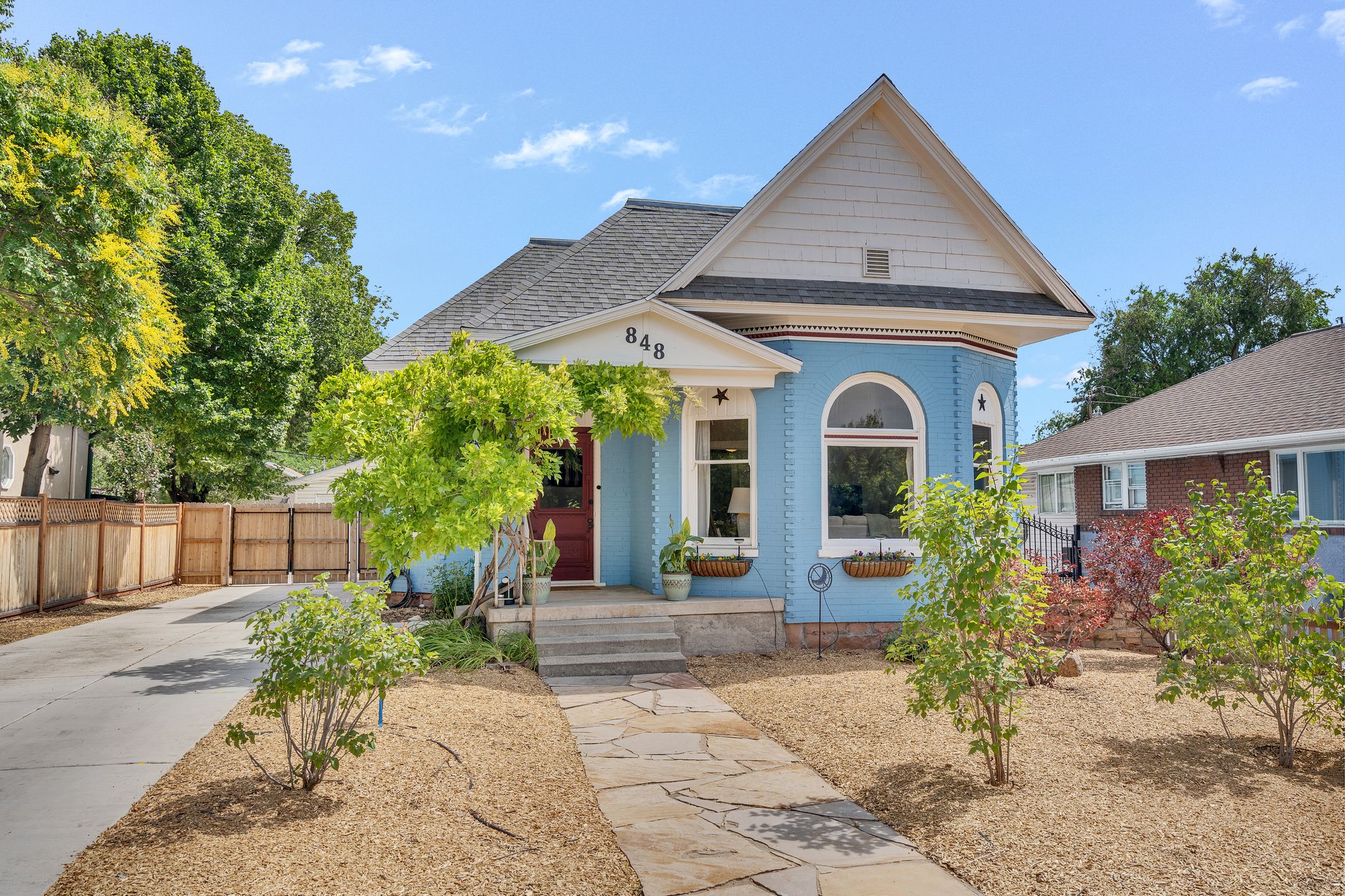 Blue brick exterior with white trim and a prominent gable