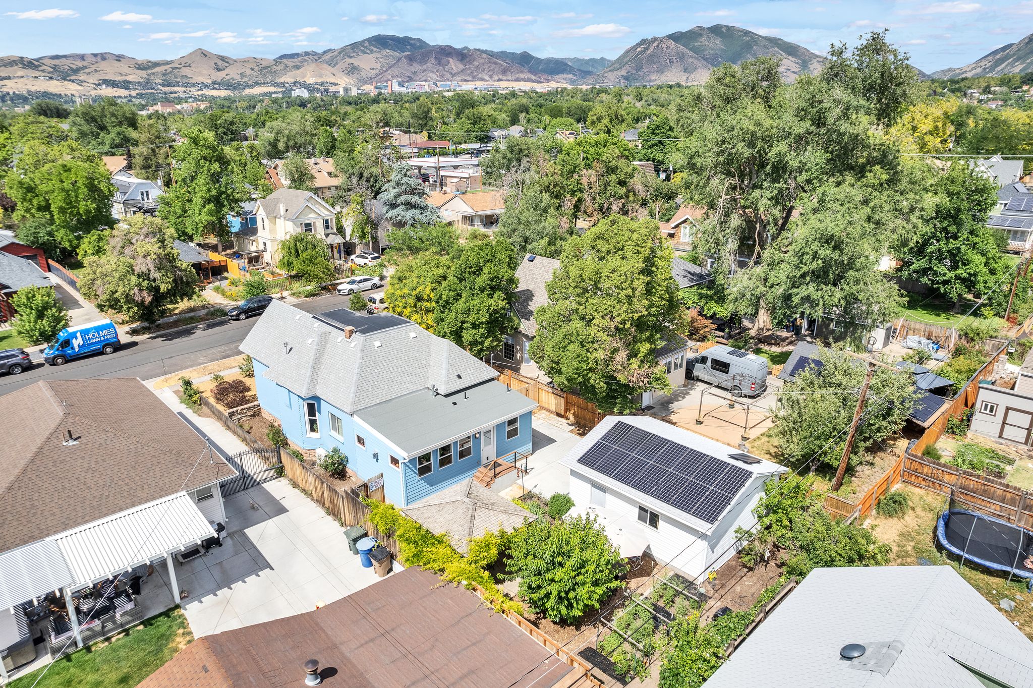 Blue exterior residence featuring a light gray shingle roof with solar panels