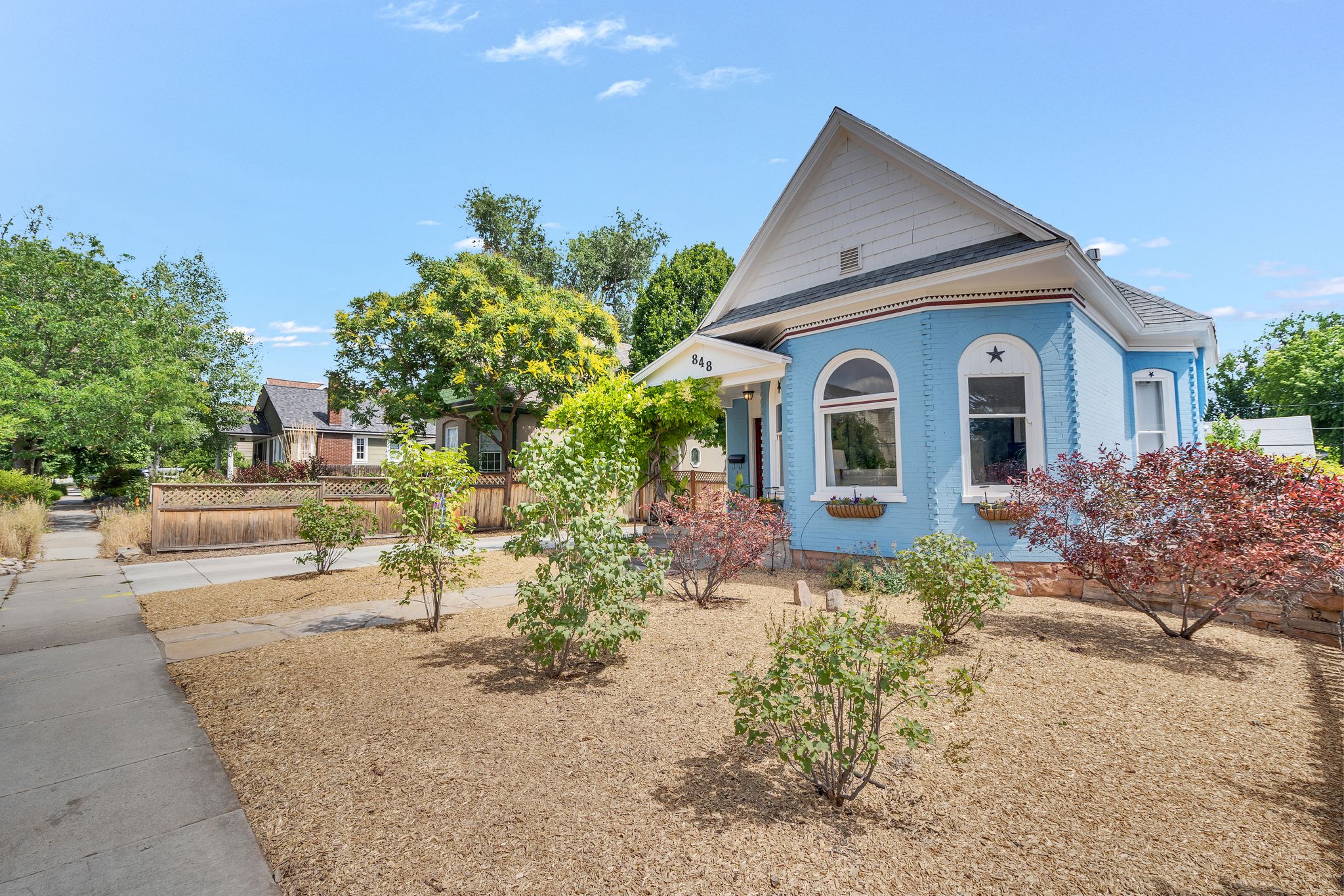 Light blue exterior with white trim, arched windows, and decorative star accent