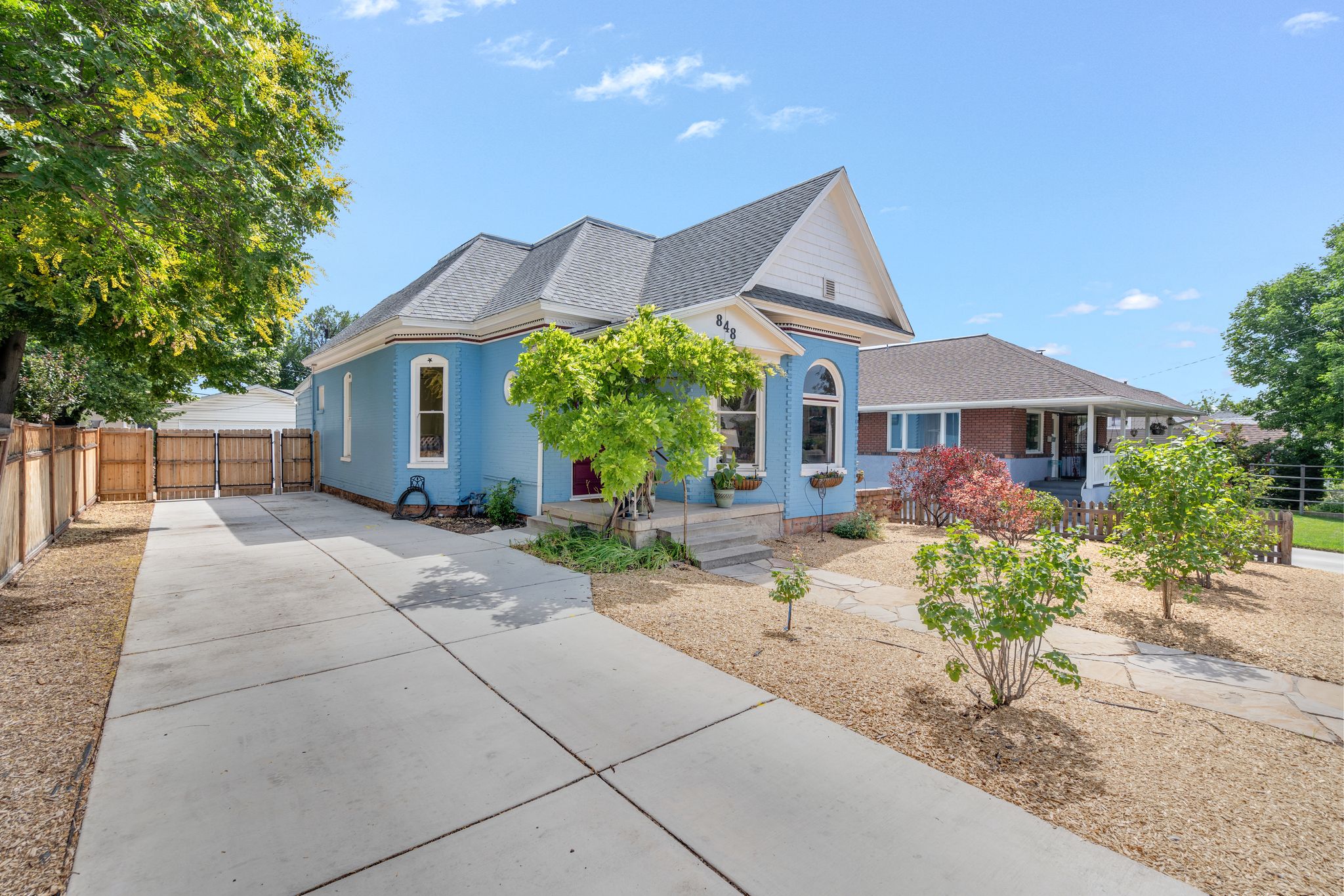 Pale blue exterior with white trim, arched windows, and a prominent front gable