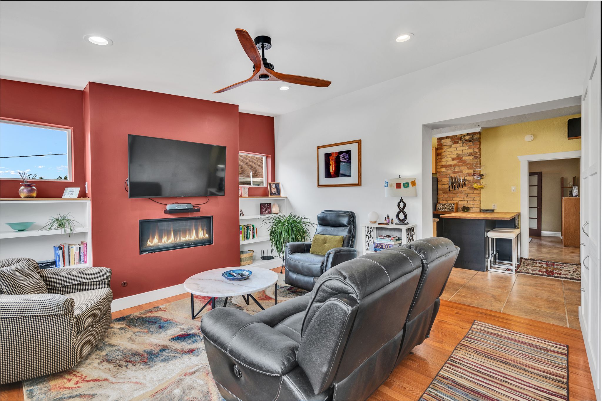 Living area with a modern linear fireplace, recessed lighting, and a ceiling fan