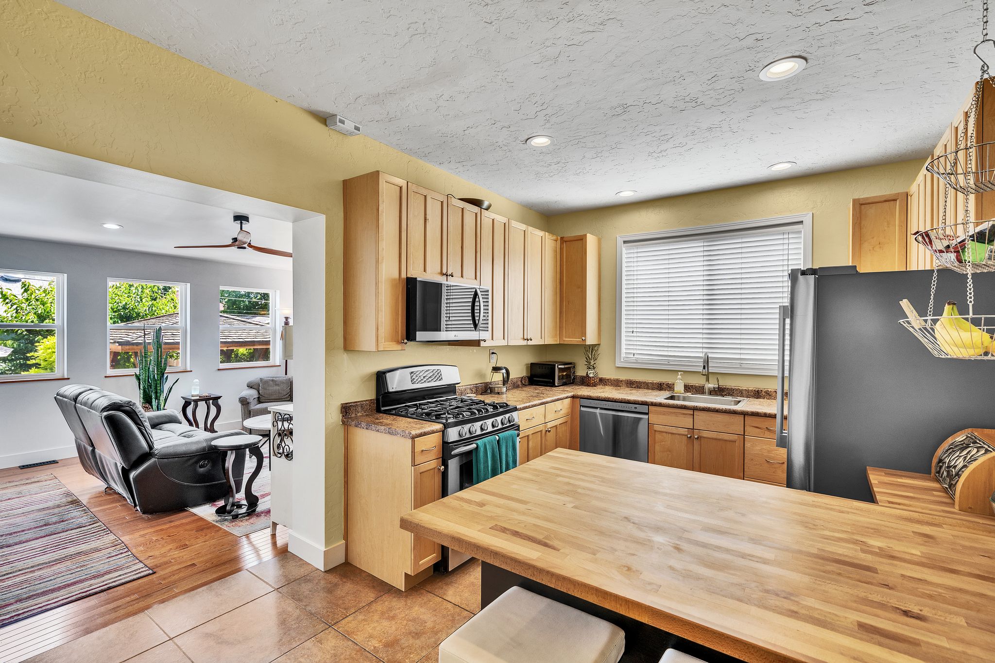 Kitchen featuring wood-finish cabinetry, stainless steel appliances, a gas range, and a wood-finish island countertop
