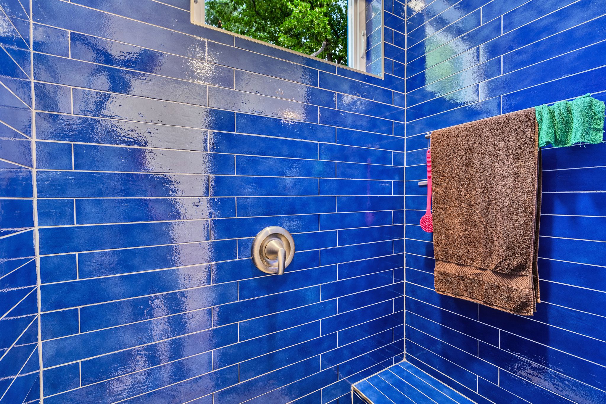 Shower enclosure featuring blue subway tile