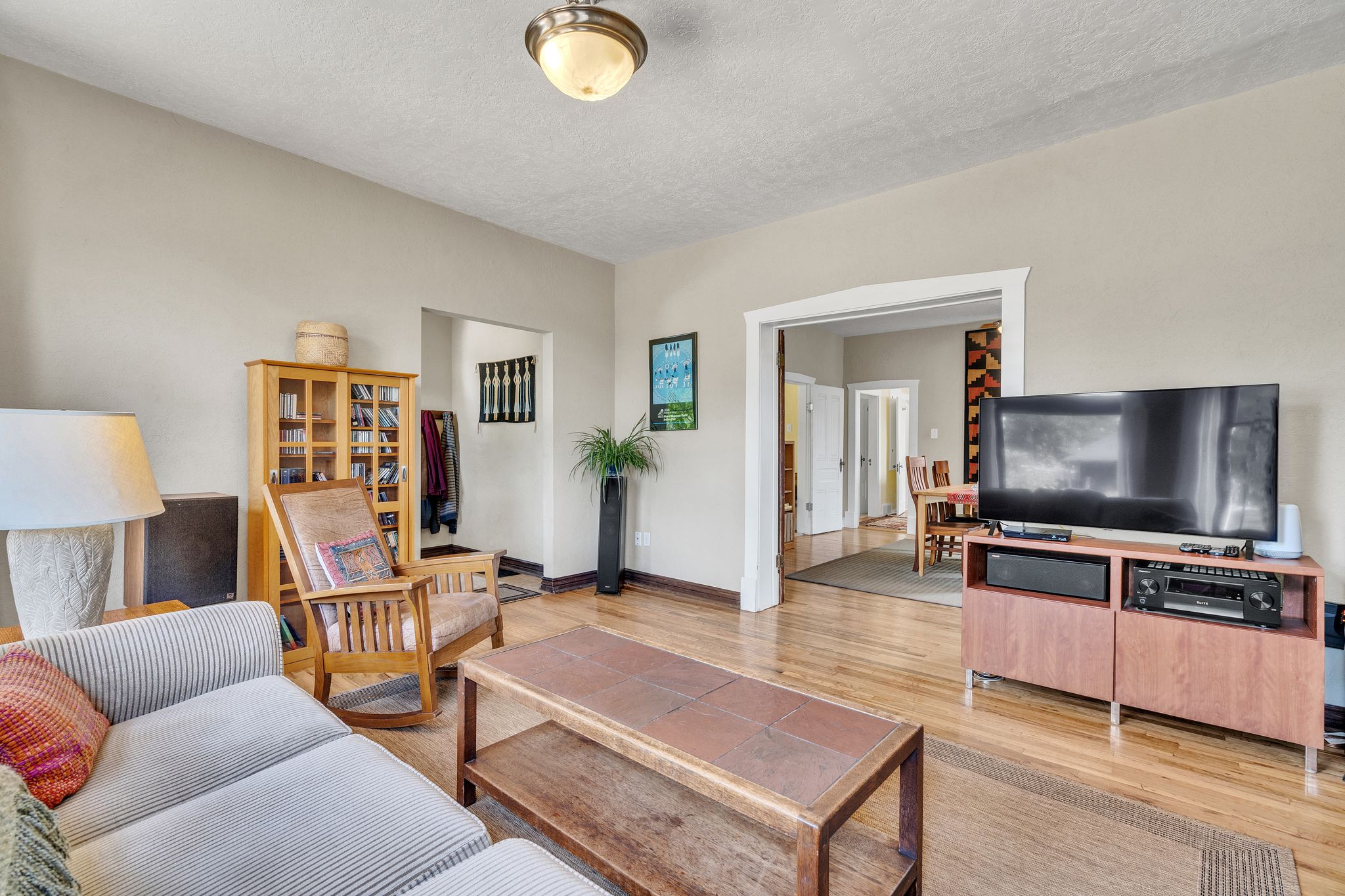 large Light-filled formal living room with beautiful hardwood floors, lots of natural light and an arched doorway leading to adjoining dining room