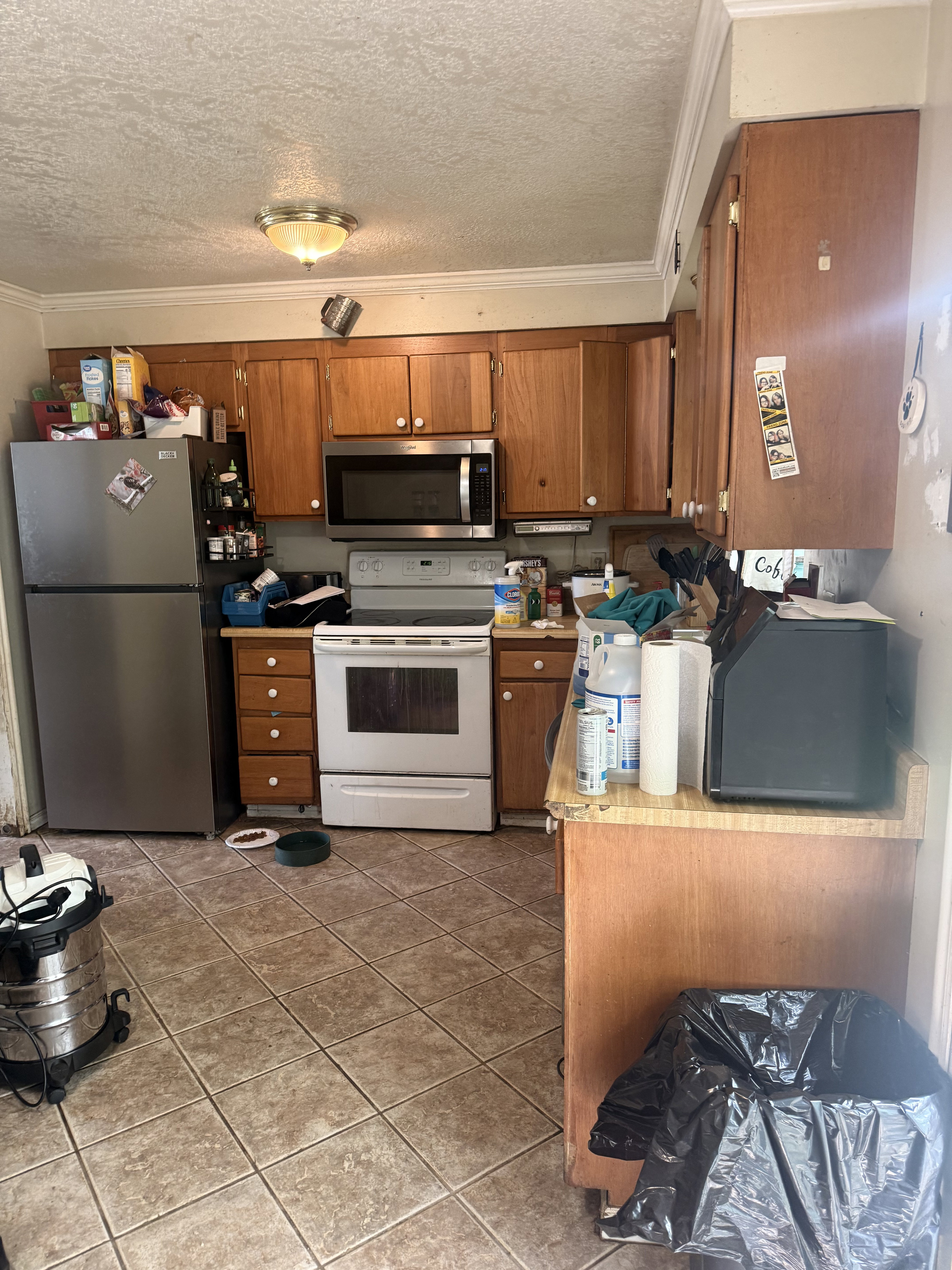Kitchen featuring light wood-finish cabinetry, a stainless steel refrigerator, and a stainless steel microwave