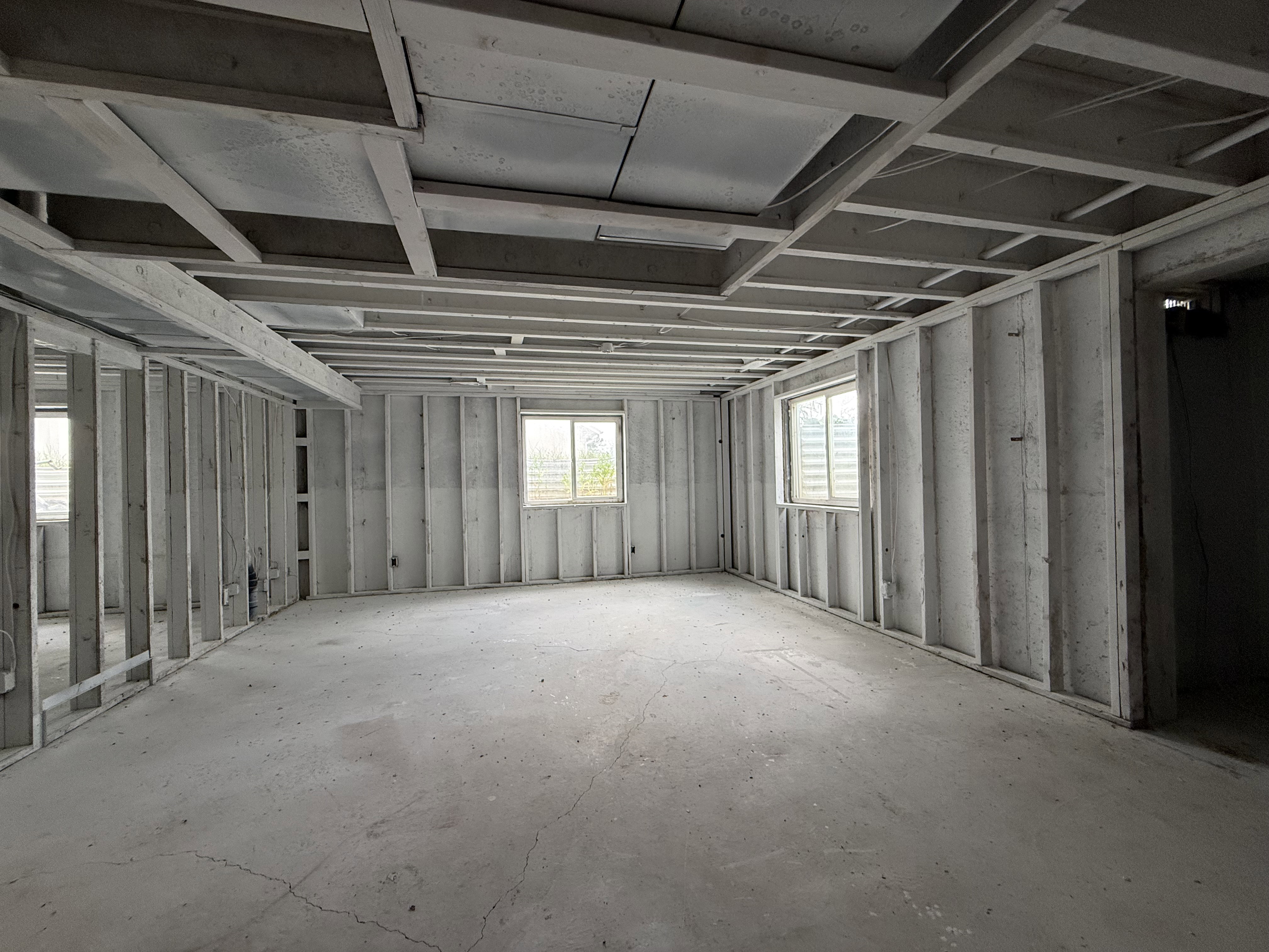 Unfinished interior space featuring exposed ceiling joists and wall studs