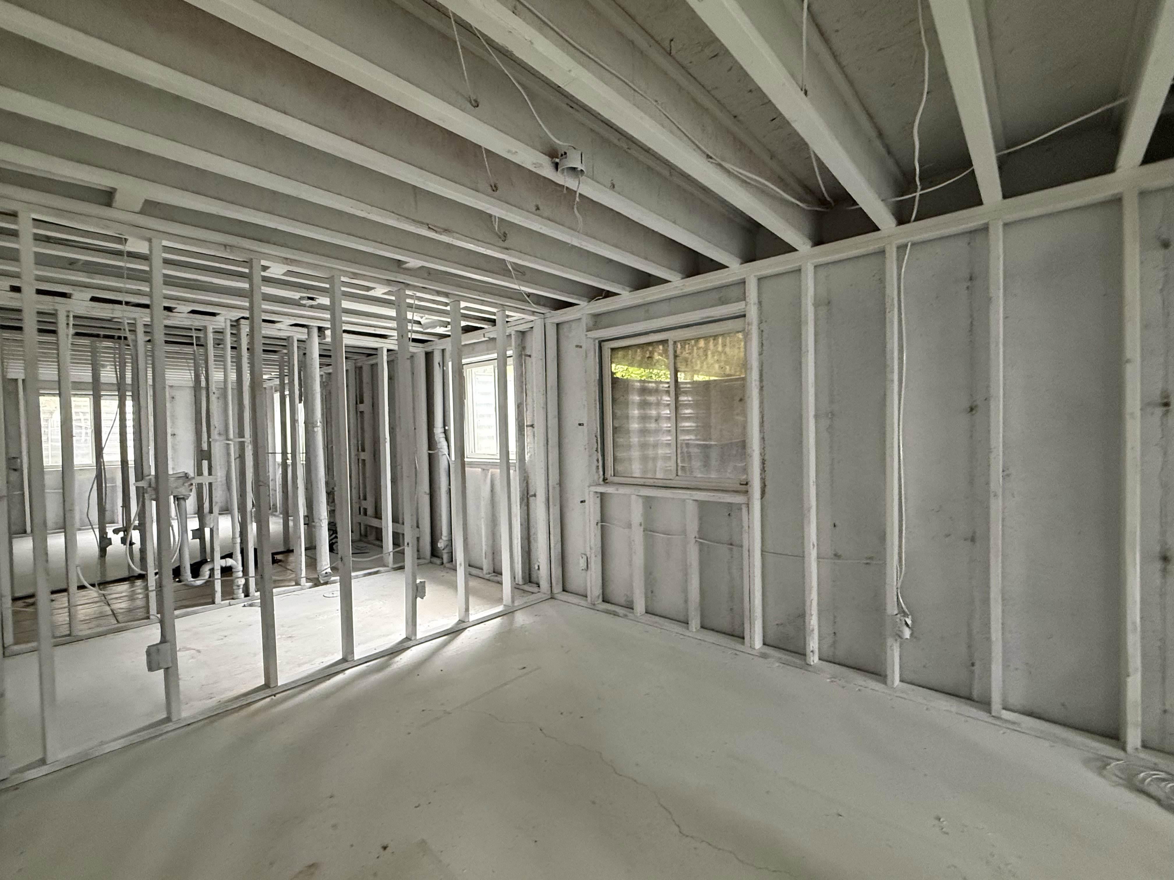 Unfinished interior space with exposed ceiling joists and wall framing