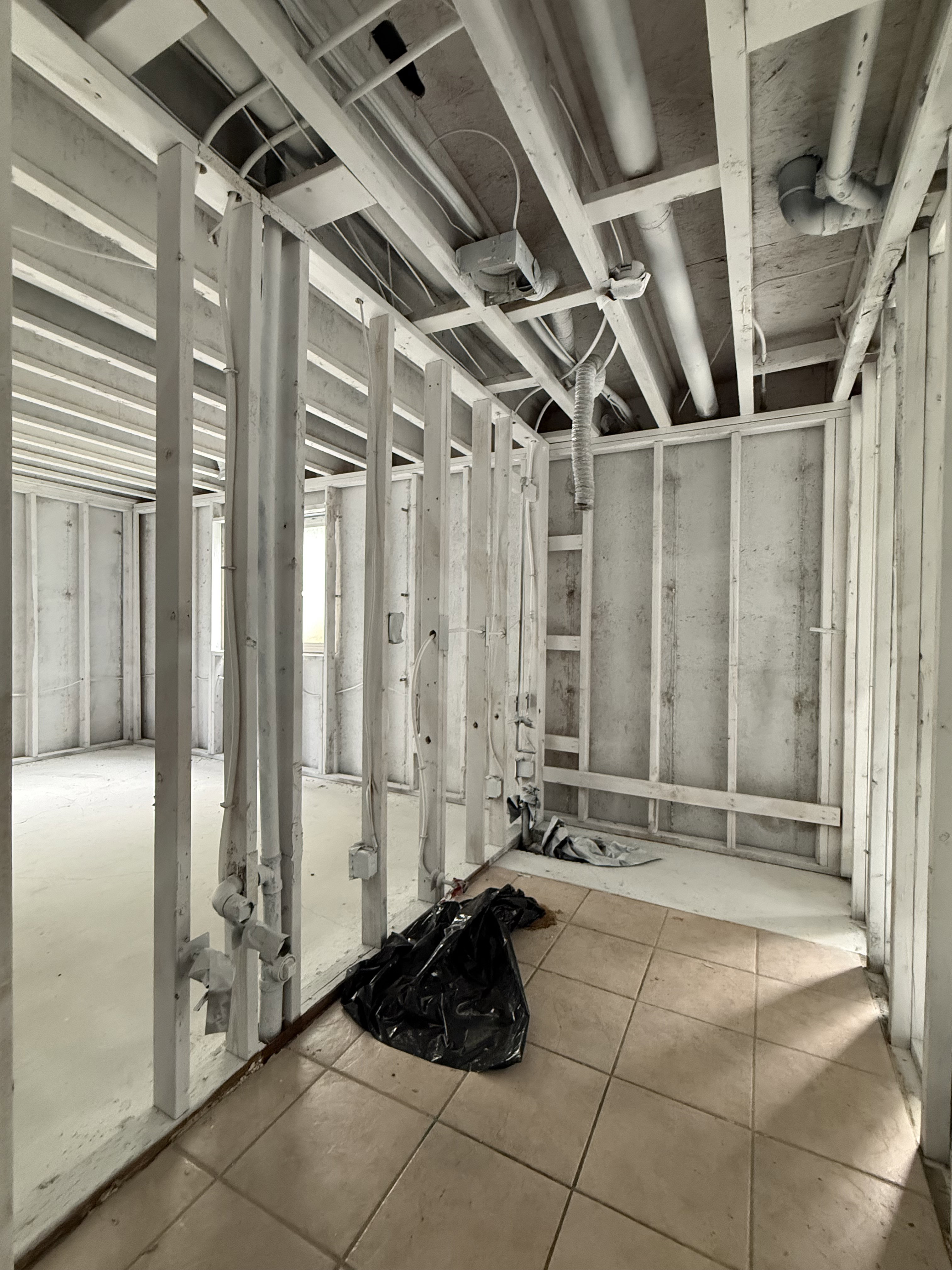 Framed interior space featuring exposed ceiling joists and wall studs