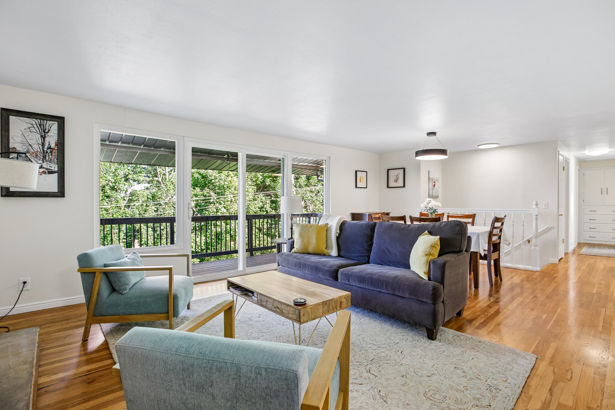 Open-concept living area featuring wood-finish flooring, white walls, and a recessed lighting fixture