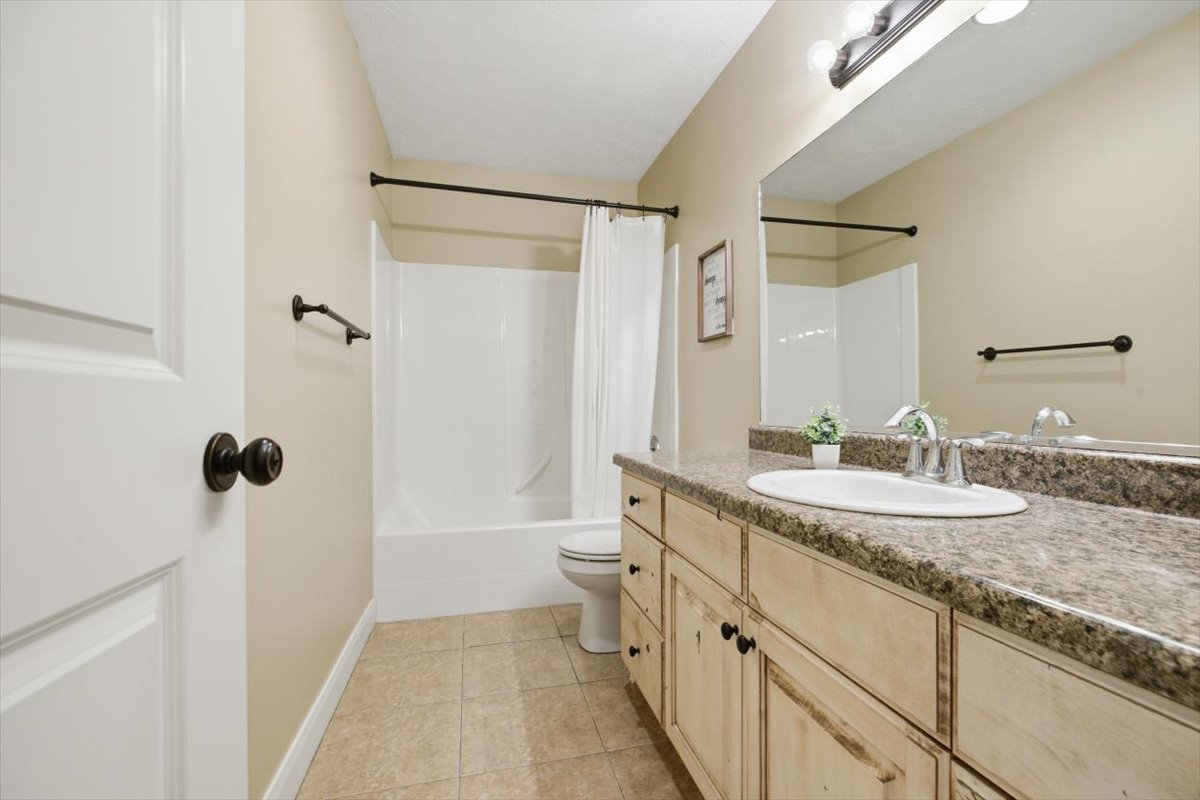 Bathroom featuring a vanity with an oval sink, an expansive mirror, and a full shower/tub combination
