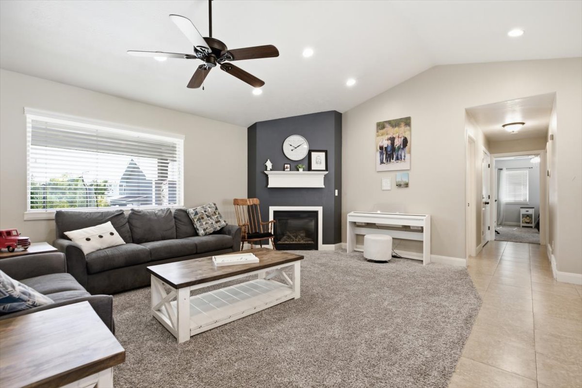 Living area featuring vaulted ceilings, recessed lighting, and a ceiling fan