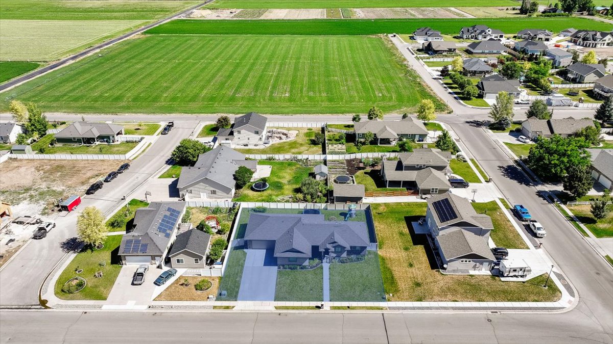Aerial view showcasing a residential property with a dark grey roof and an attached garage