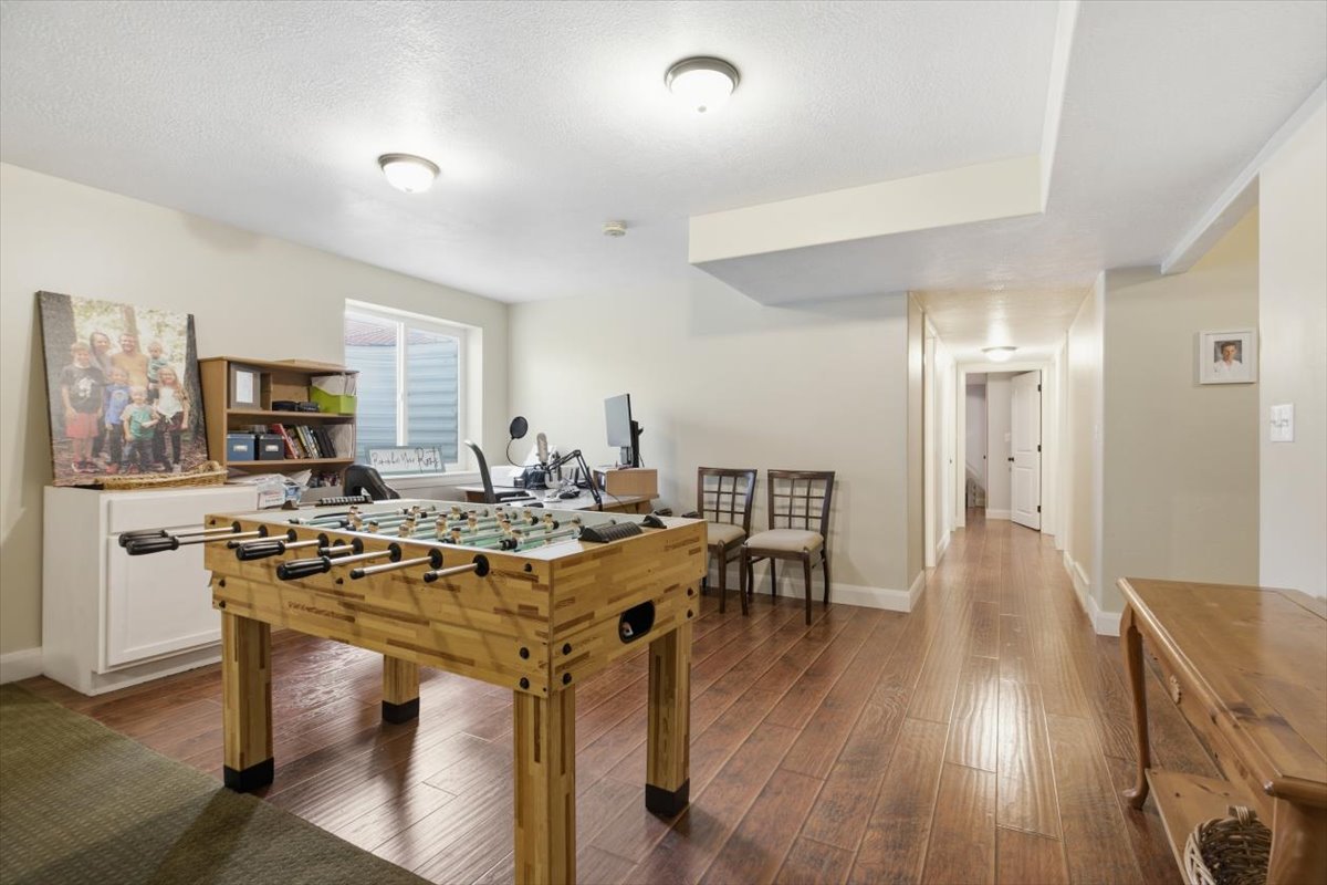 Versatile room featuring wood-finish flooring, a functional window, and overhead lighting
