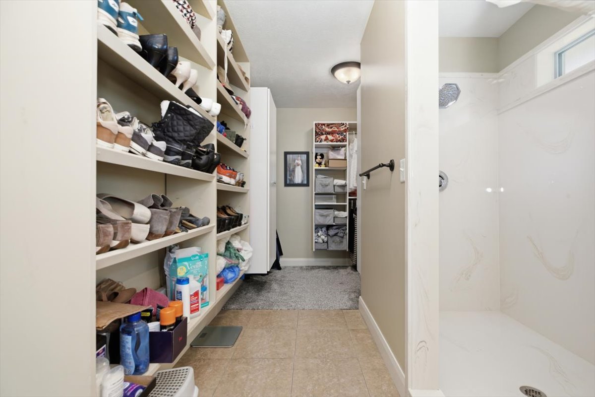 Walk-in shower with a chrome rainfall showerhead and a transom window