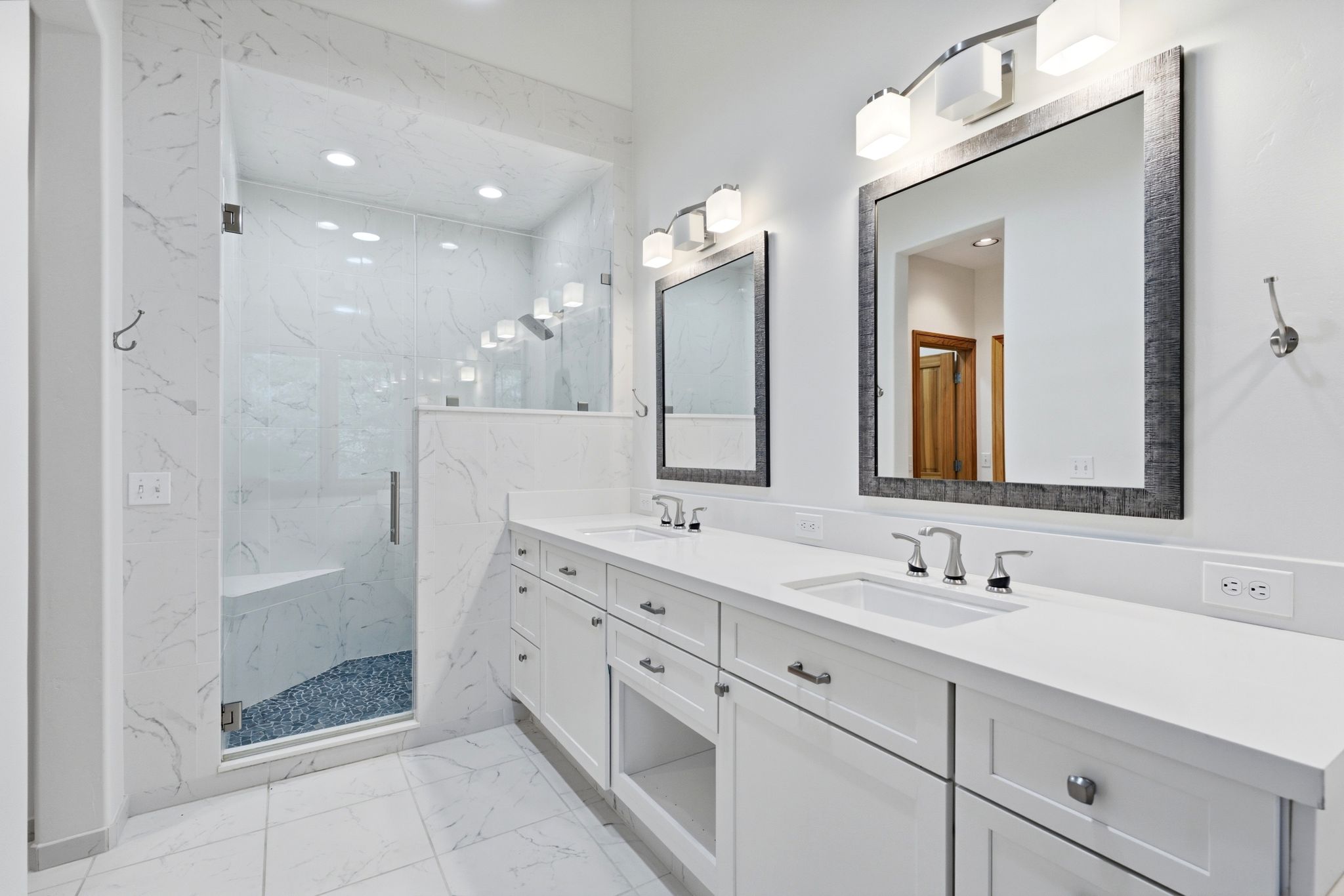 Dual vanity with white cabinetry and integrated sinks, quartz countertops, and brushed nickel fixtures