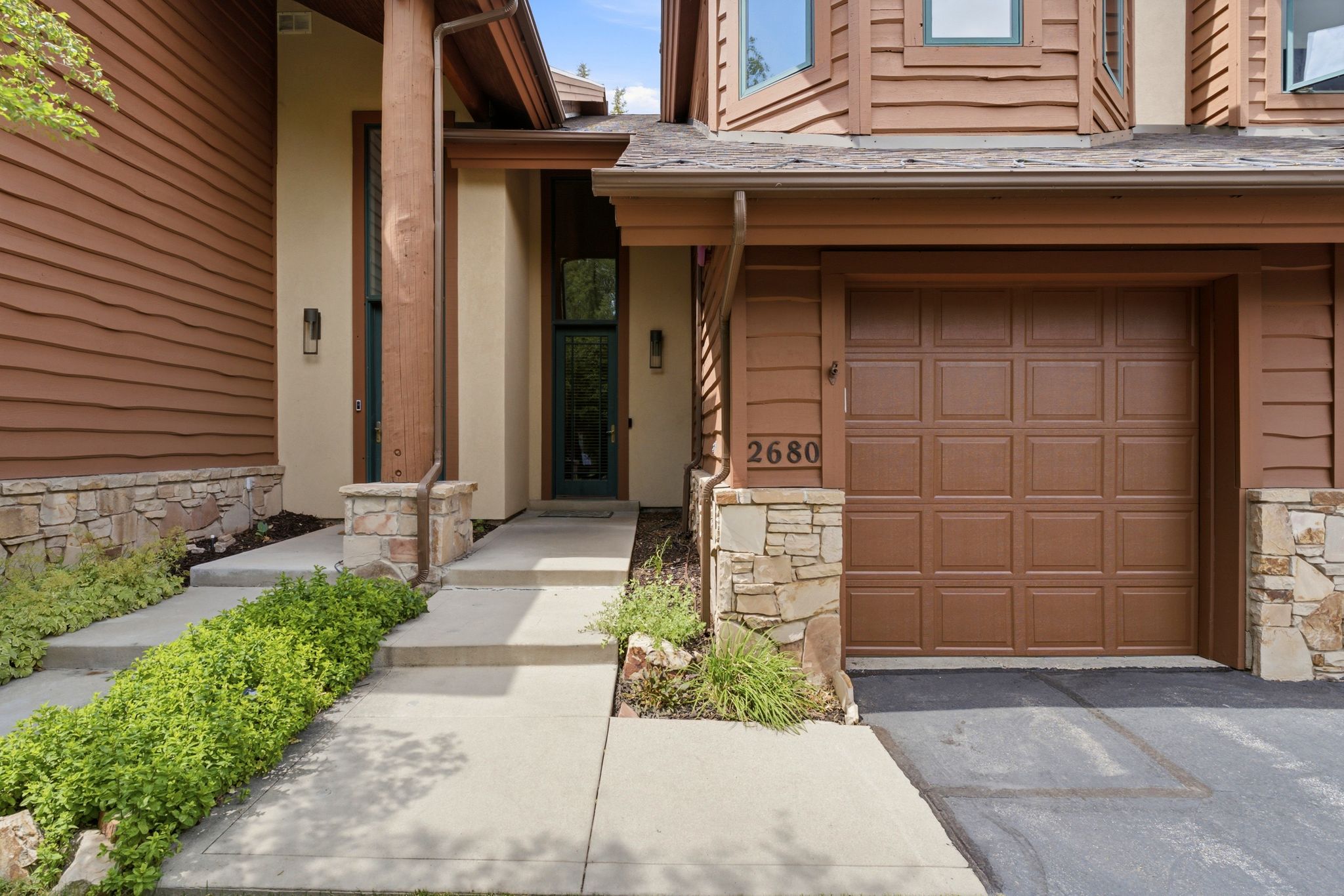 Exterior showcasing horizontal wood siding and stacked stone accents