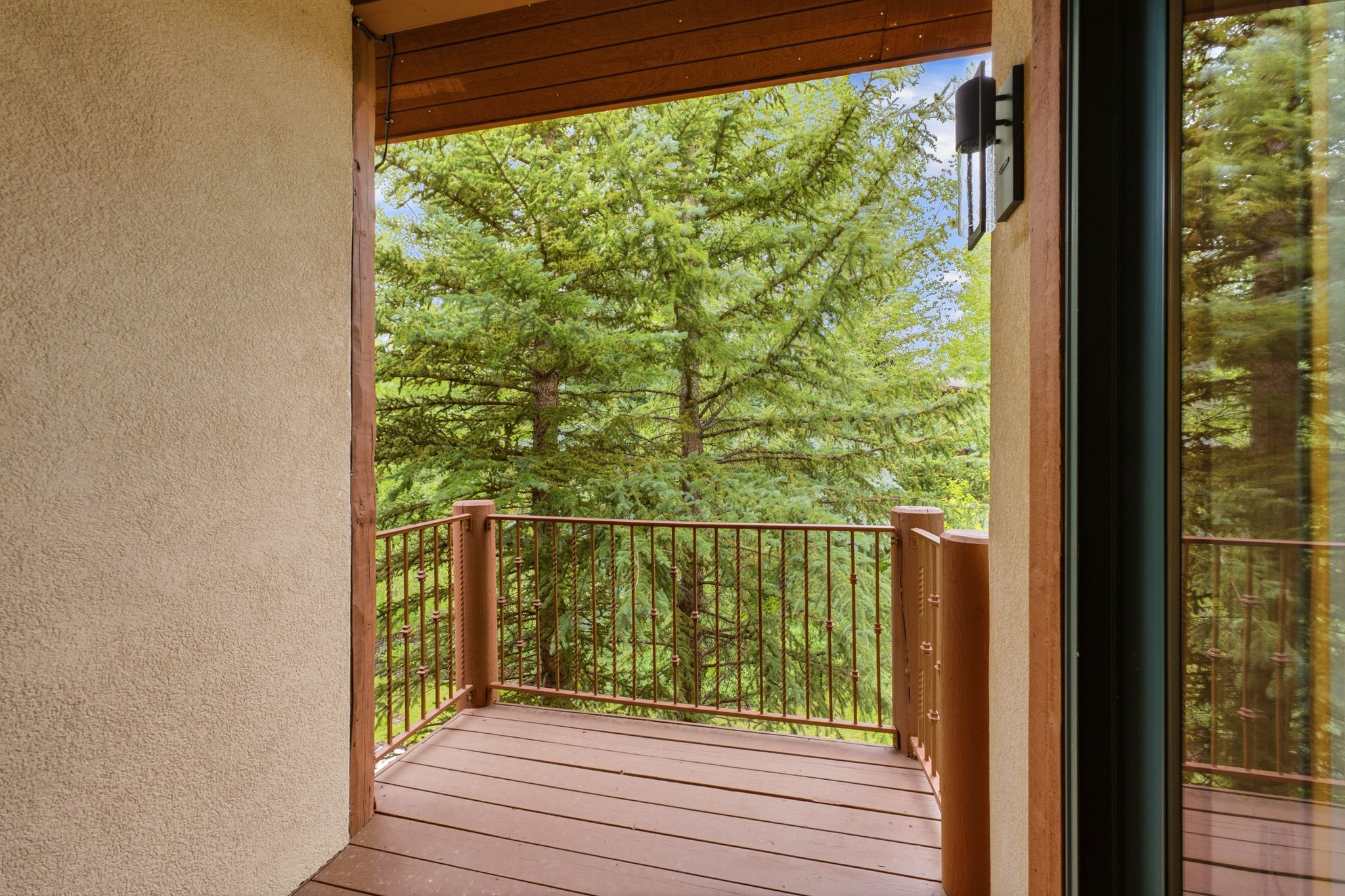 Private balcony featuring wood-finish decking and wood-tone railing
