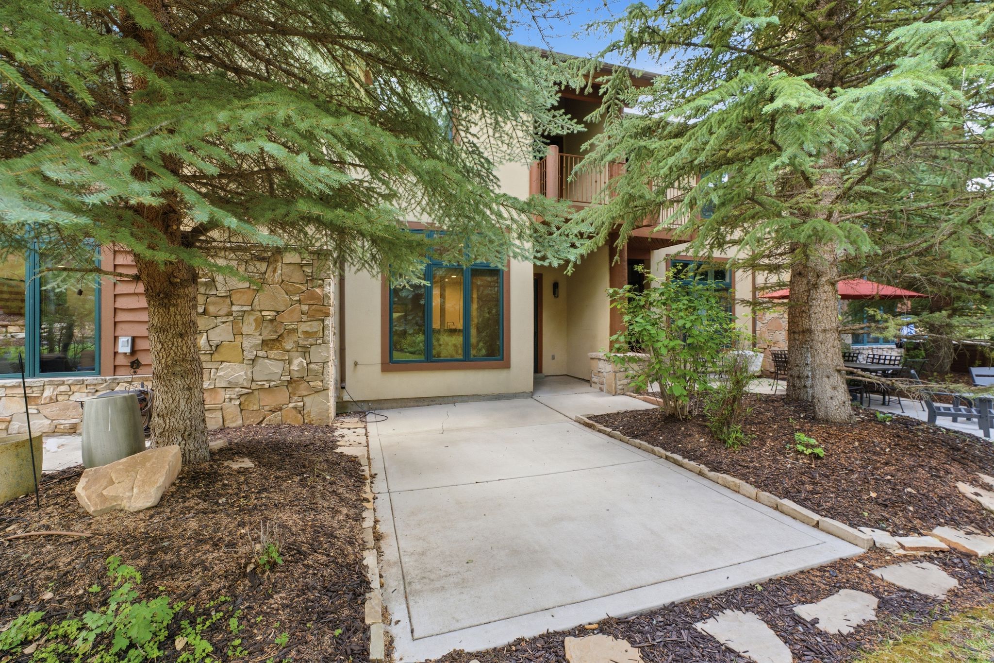 Multi-level exterior featuring stone veneer and stucco siding