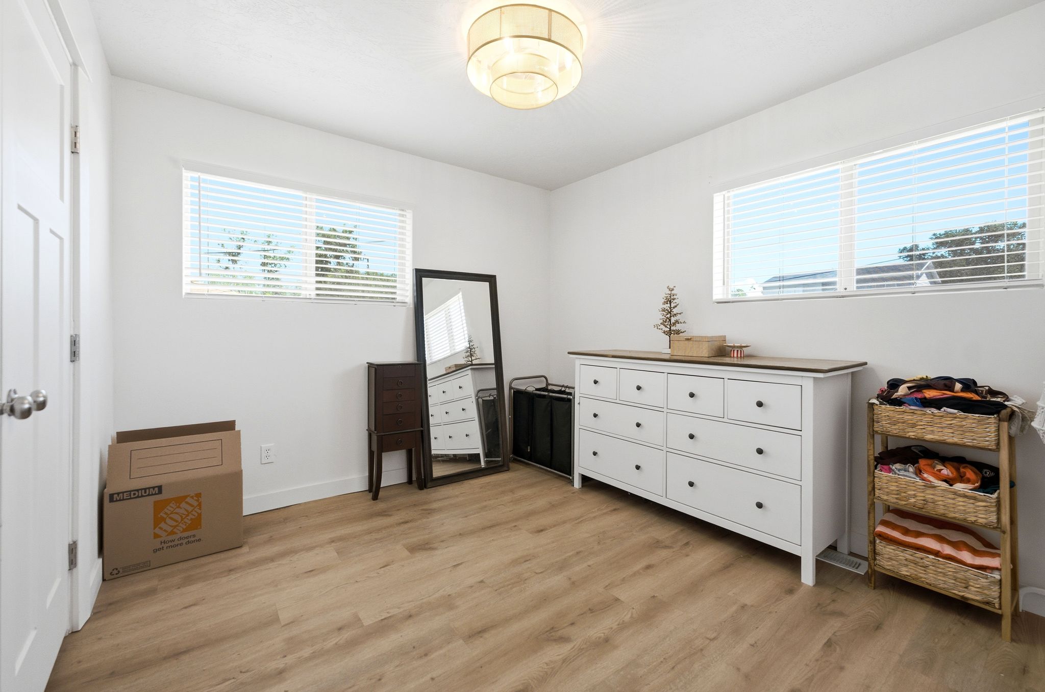 Bright interior space featuring wood-finish flooring, white walls, and a contemporary flush-mount ceiling light