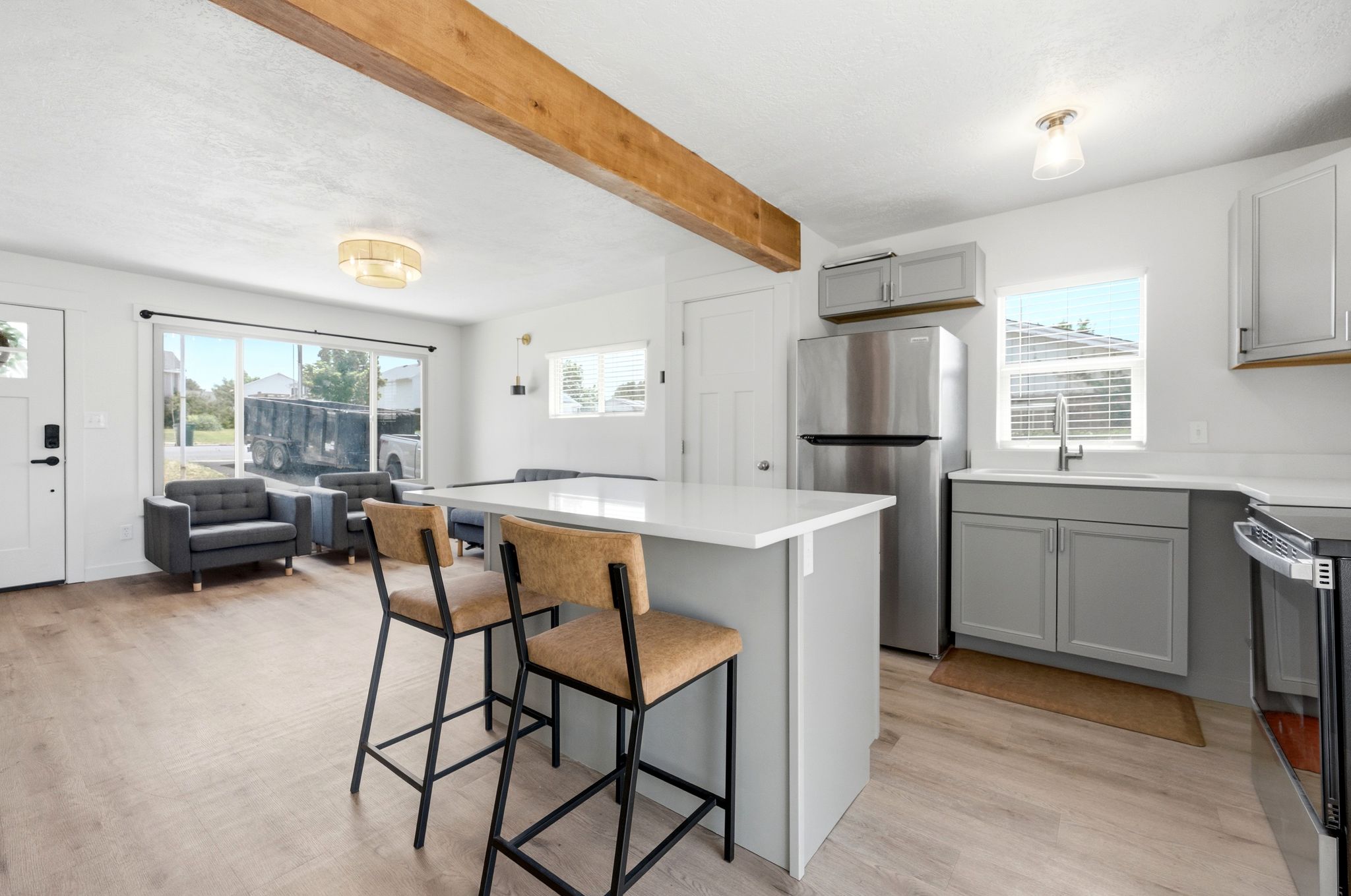 Open-concept living space featuring wood-finish flooring and a prominent exposed beam
