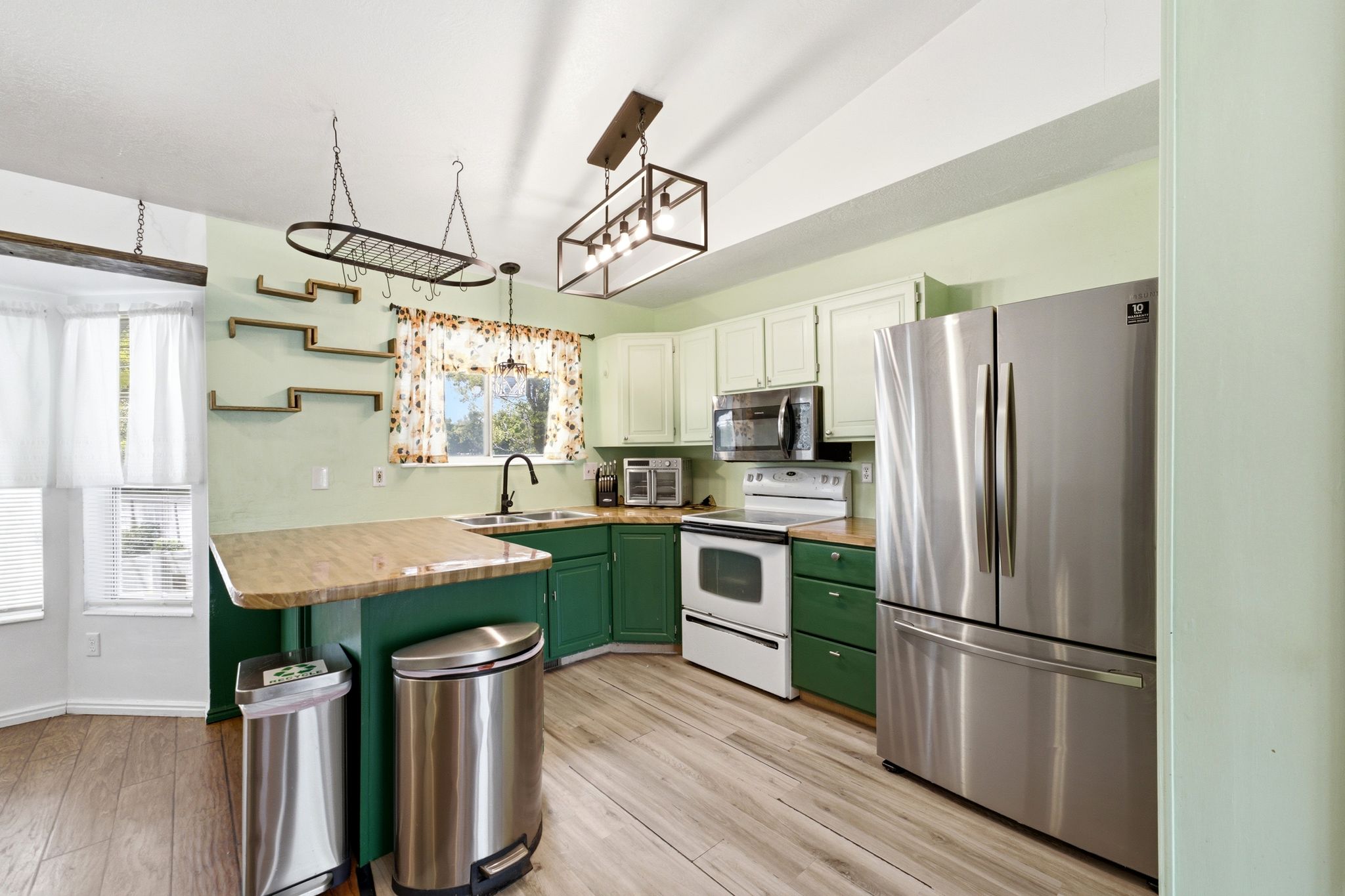Kitchen featuring wood-finish flooring and two-tone cabinetry