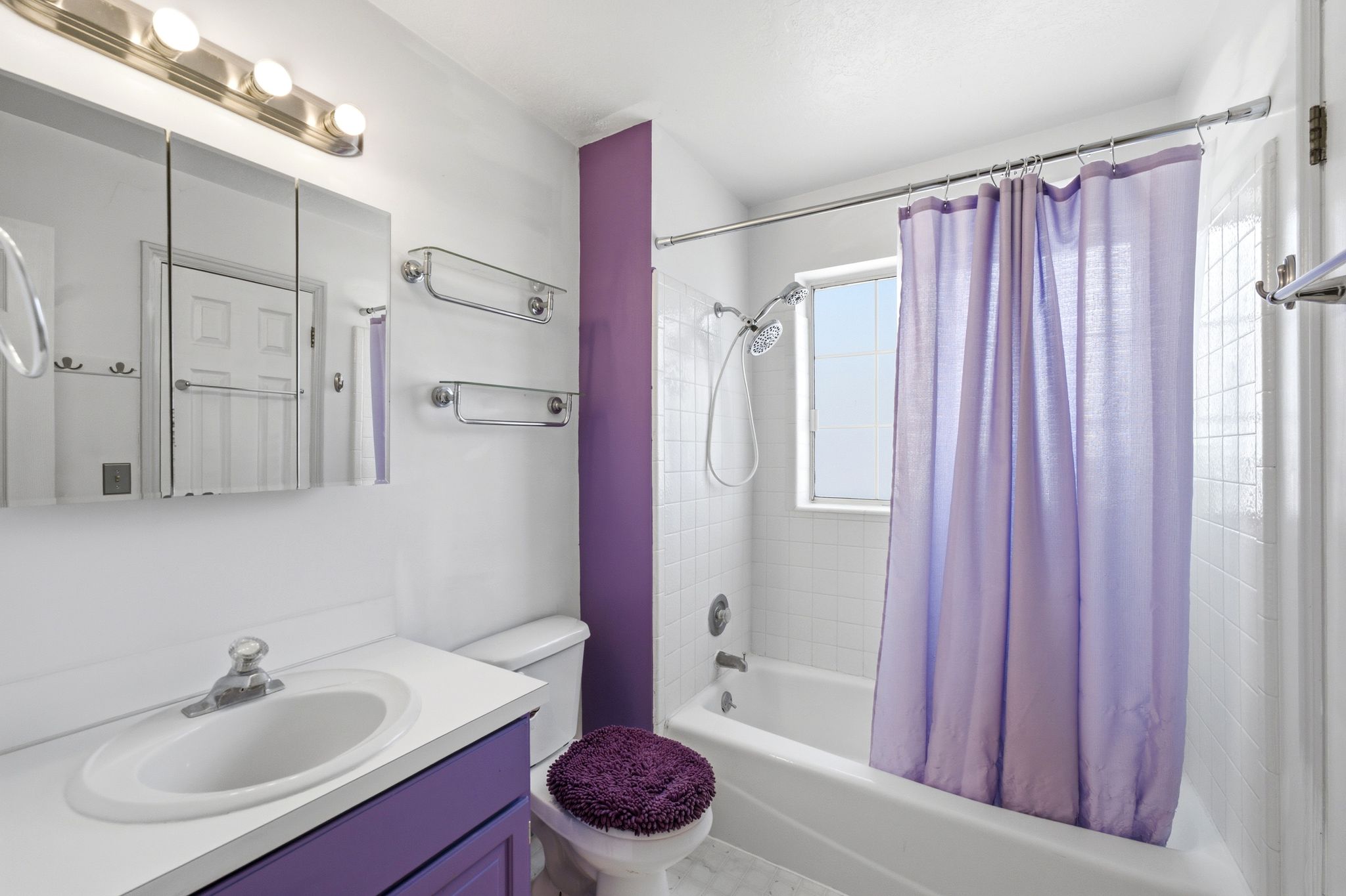 Full bathroom featuring a white vanity with an integrated sink, a built-in medicine cabinet, and a shower-over-tub combination with white subway tile surround