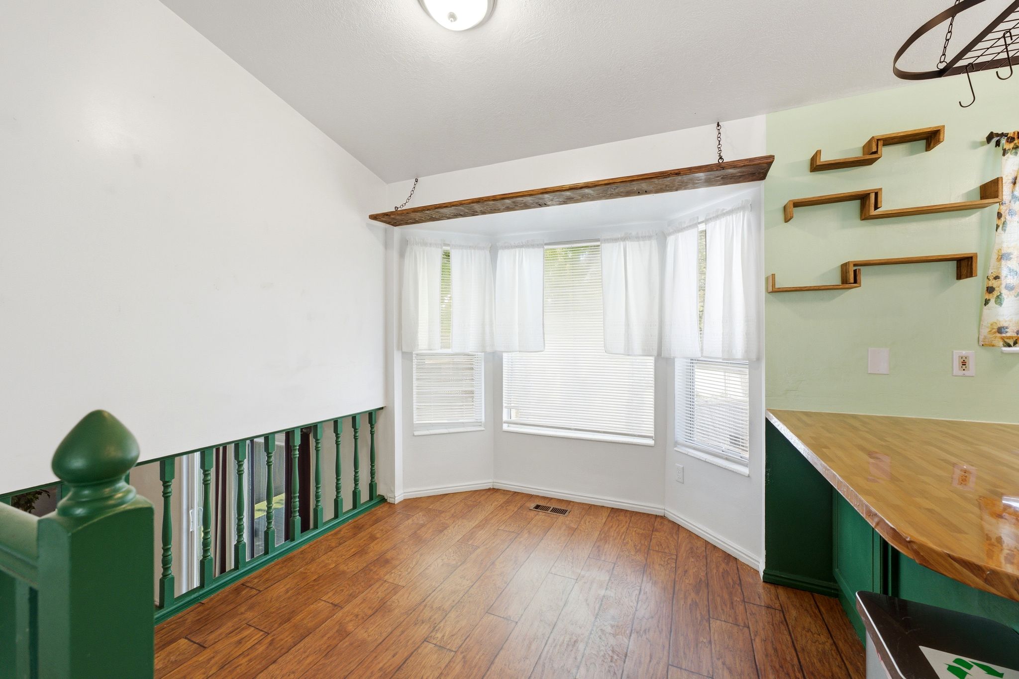 Bay window area featuring wood-finish flooring and a white color palette