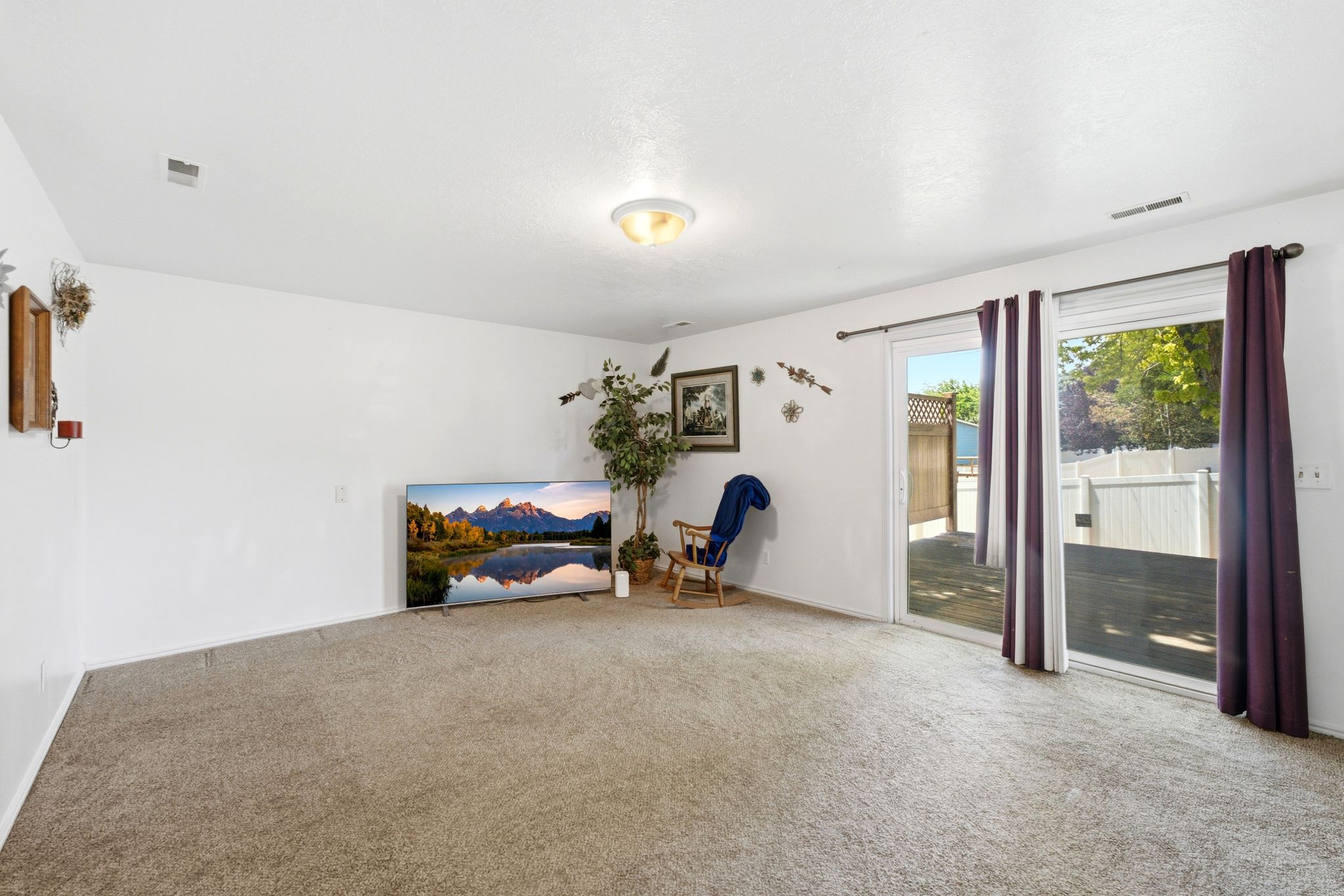 Carpeted interior space featuring white walls and a ceiling-mounted light fixture