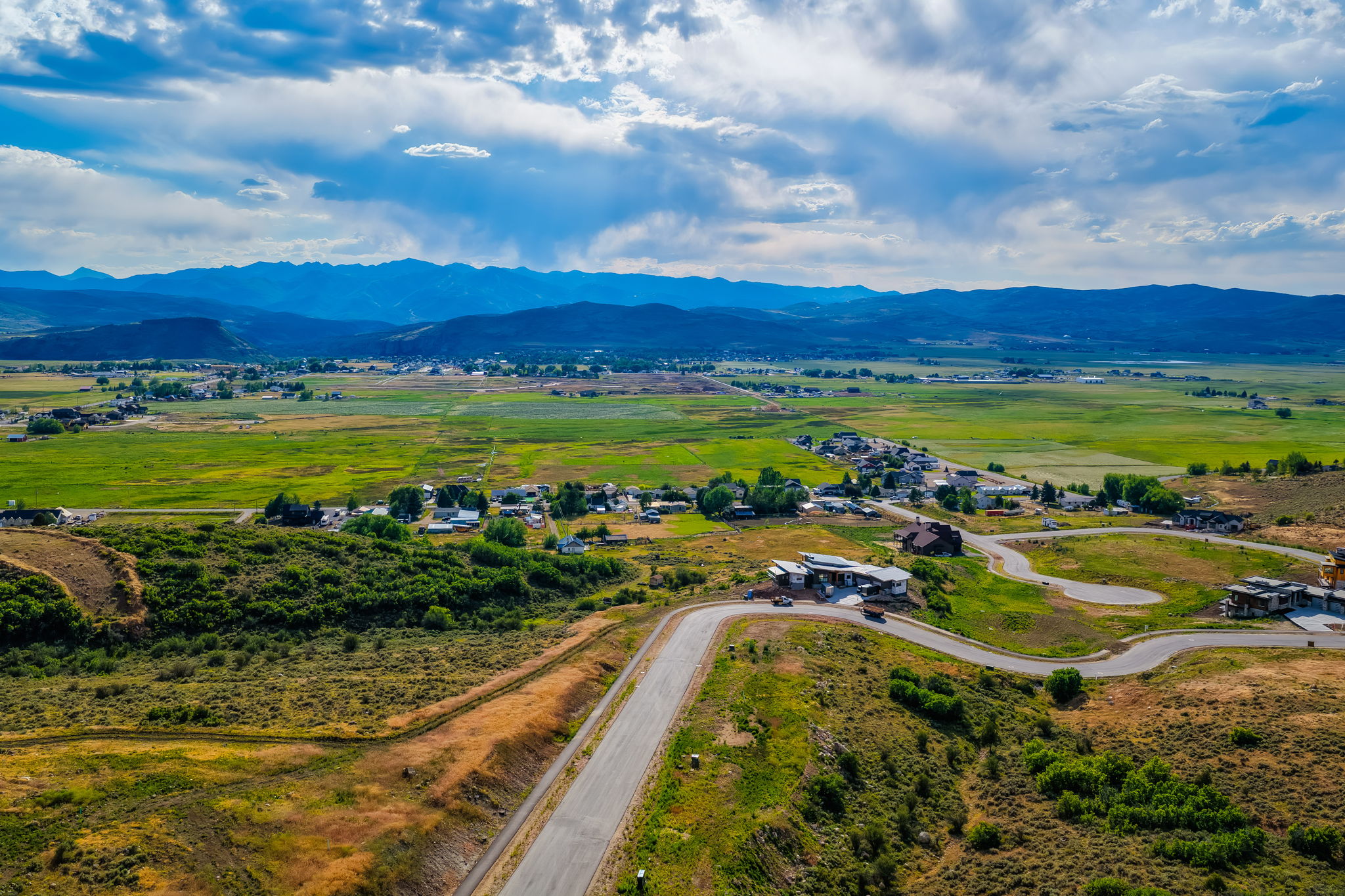 Expansive mountain-range backdrop framing a verdant valley with established communities