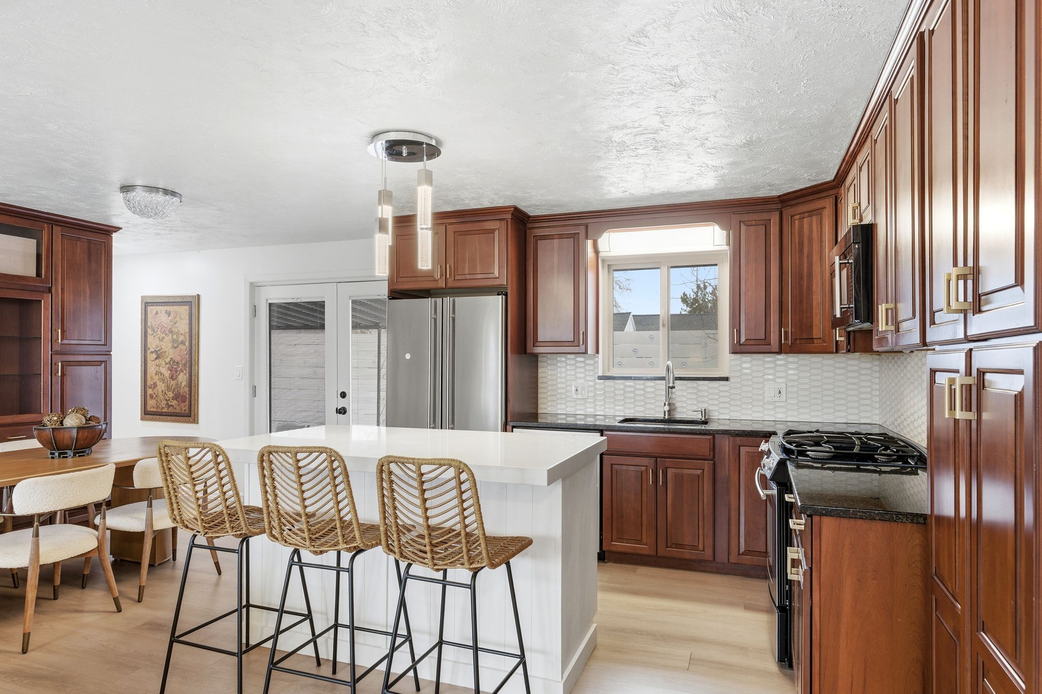 Kitchen featuring wood-finish cabinetry, a white quartz island, stainless steel appliances, and wood-finish flooring