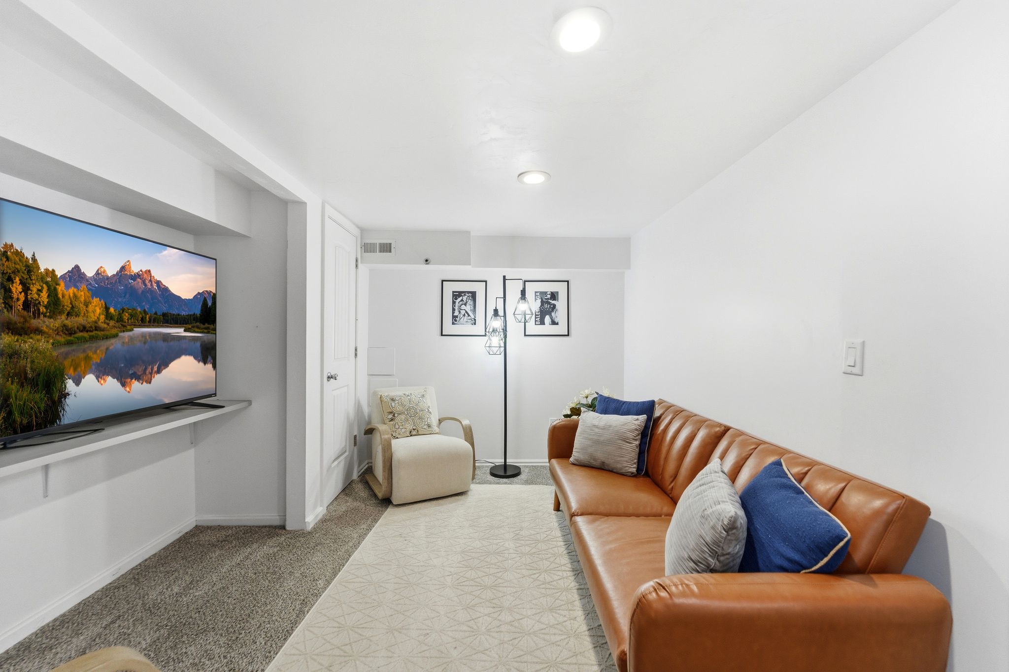 Spacious entertainment area featuring recessed lighting, a built-in media shelf, and neutral carpeting