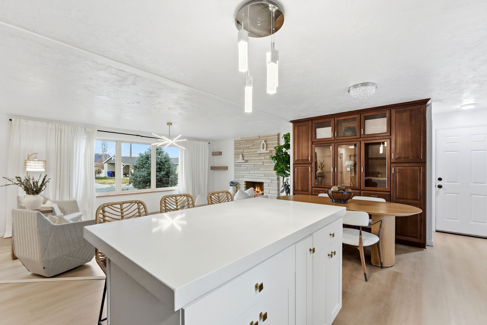 Contemporary kitchen island with a white solid surface countertop and brass hardware