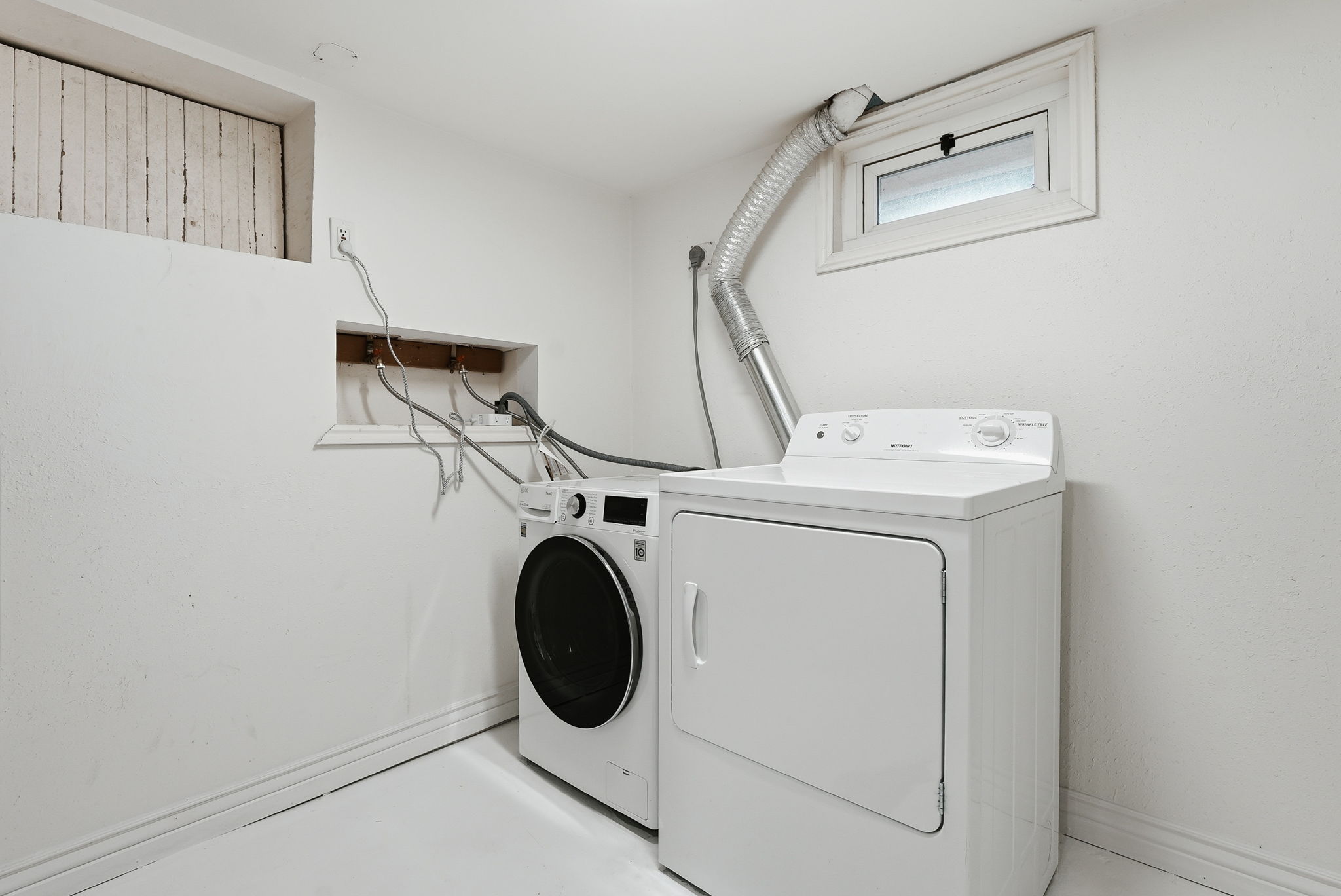 Dedicated laundry area featuring a front-loading washing machine and a top-loading dryer