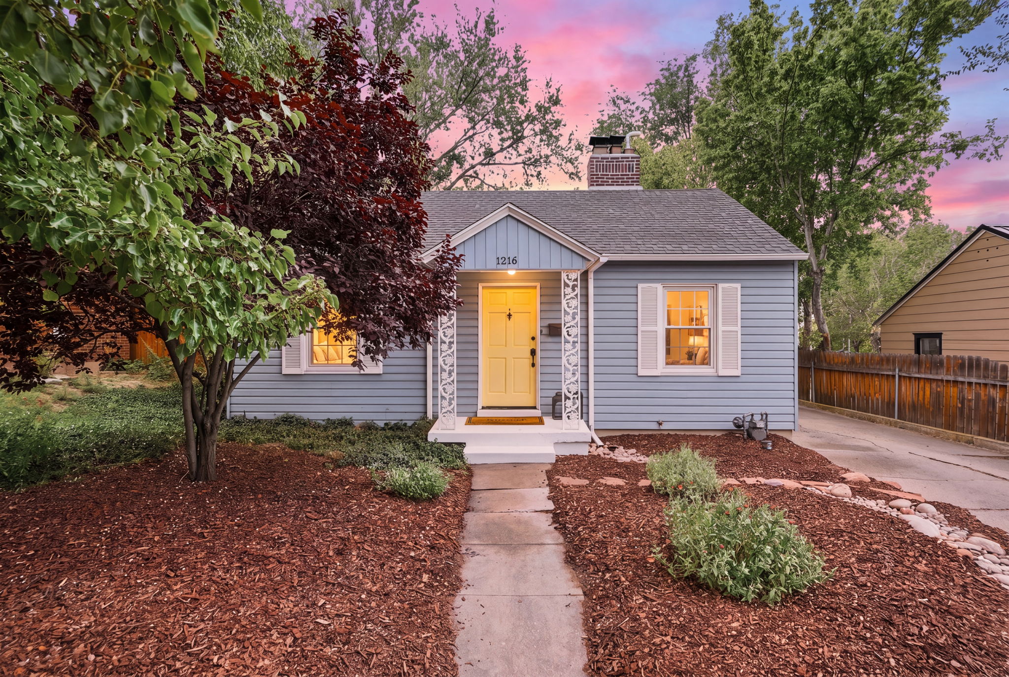 Charming single-story residence featuring light blue siding with white trim and shutters