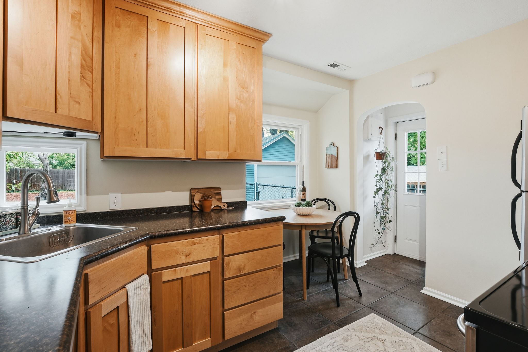 Kitchen featuring light wood cabinetry and dark stone countertops