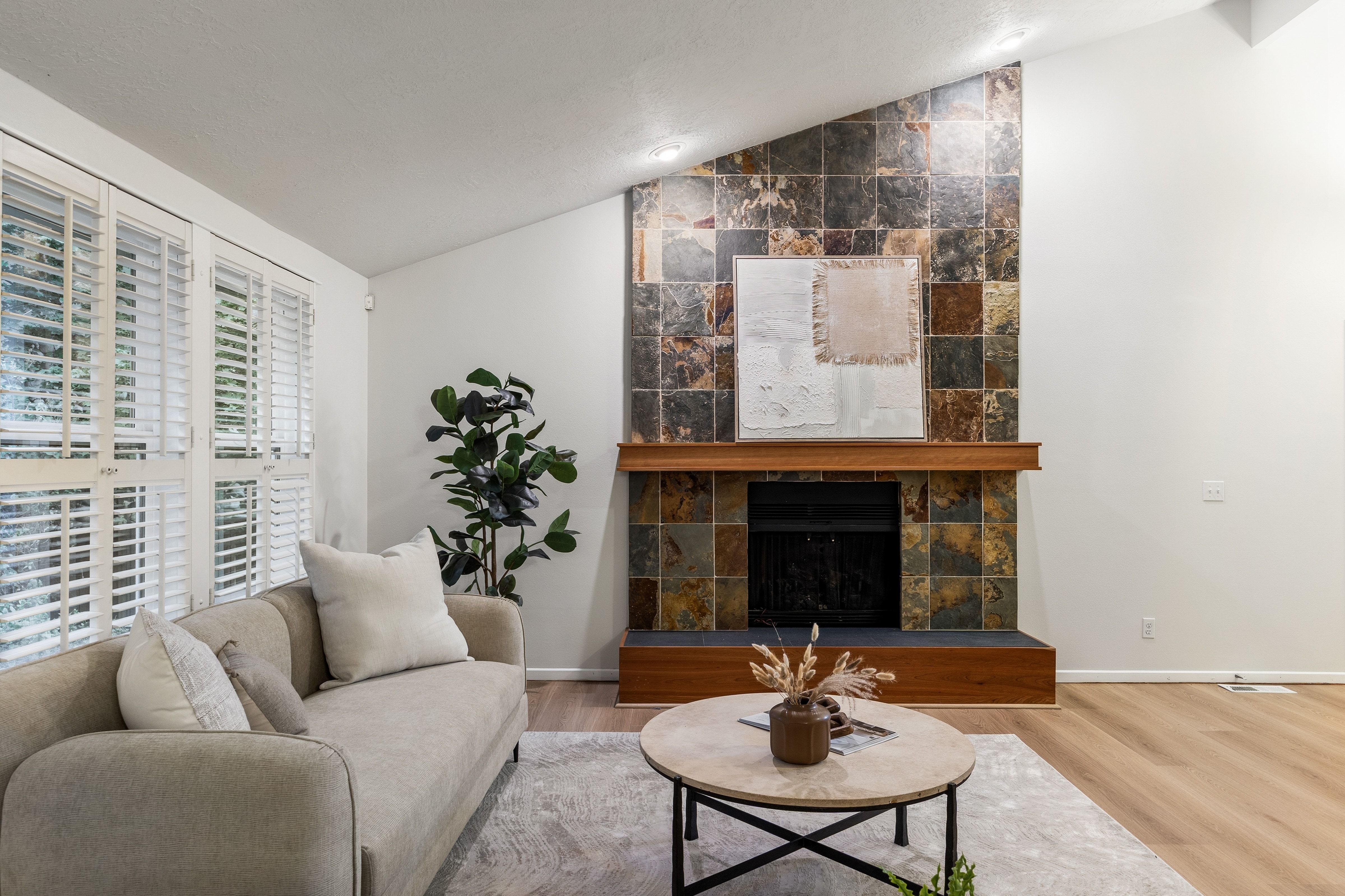 Living area featuring a floor-to-ceiling fireplace with stone tile surround and a wood mantel