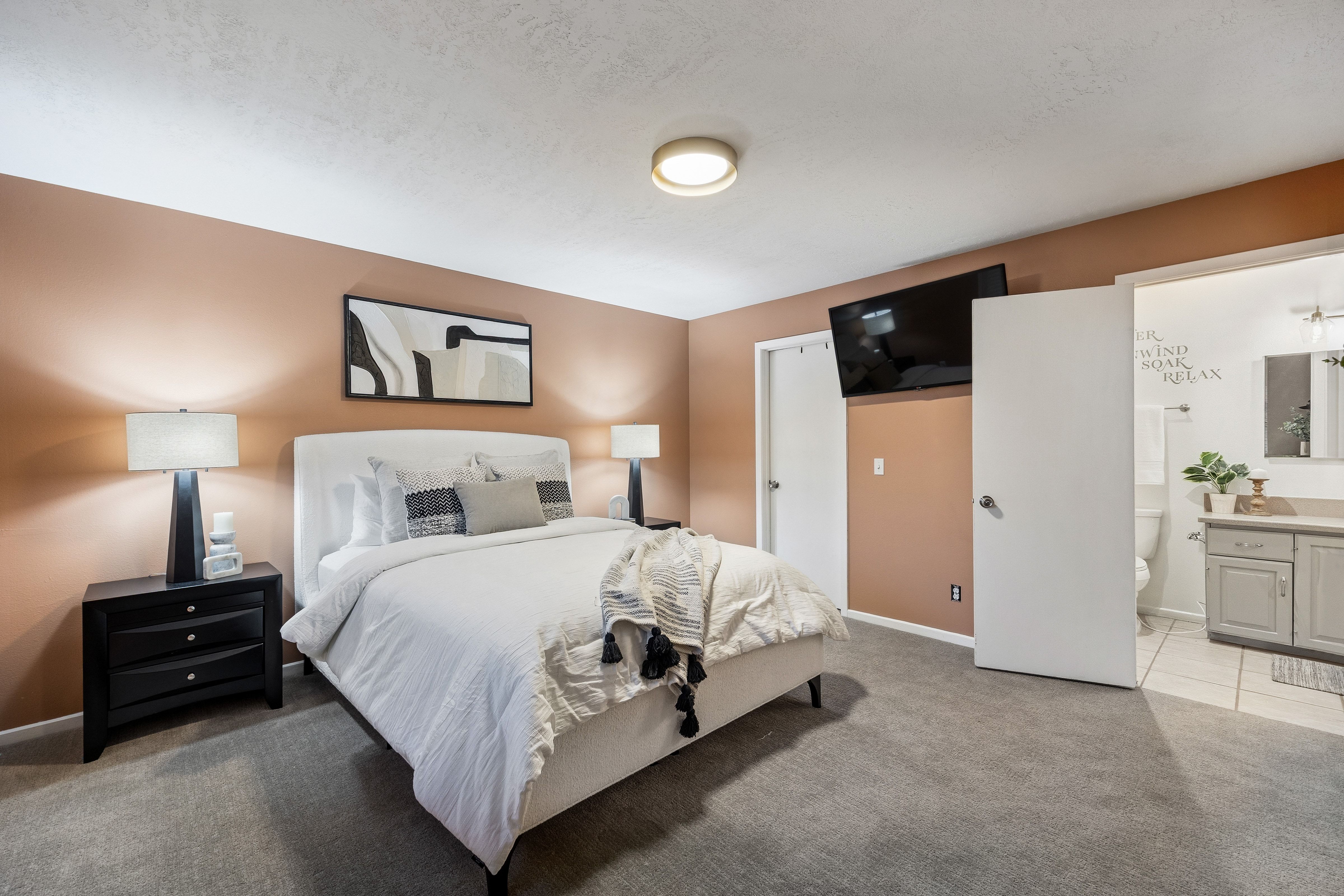 Bedroom featuring warm-toned walls and gray carpeting