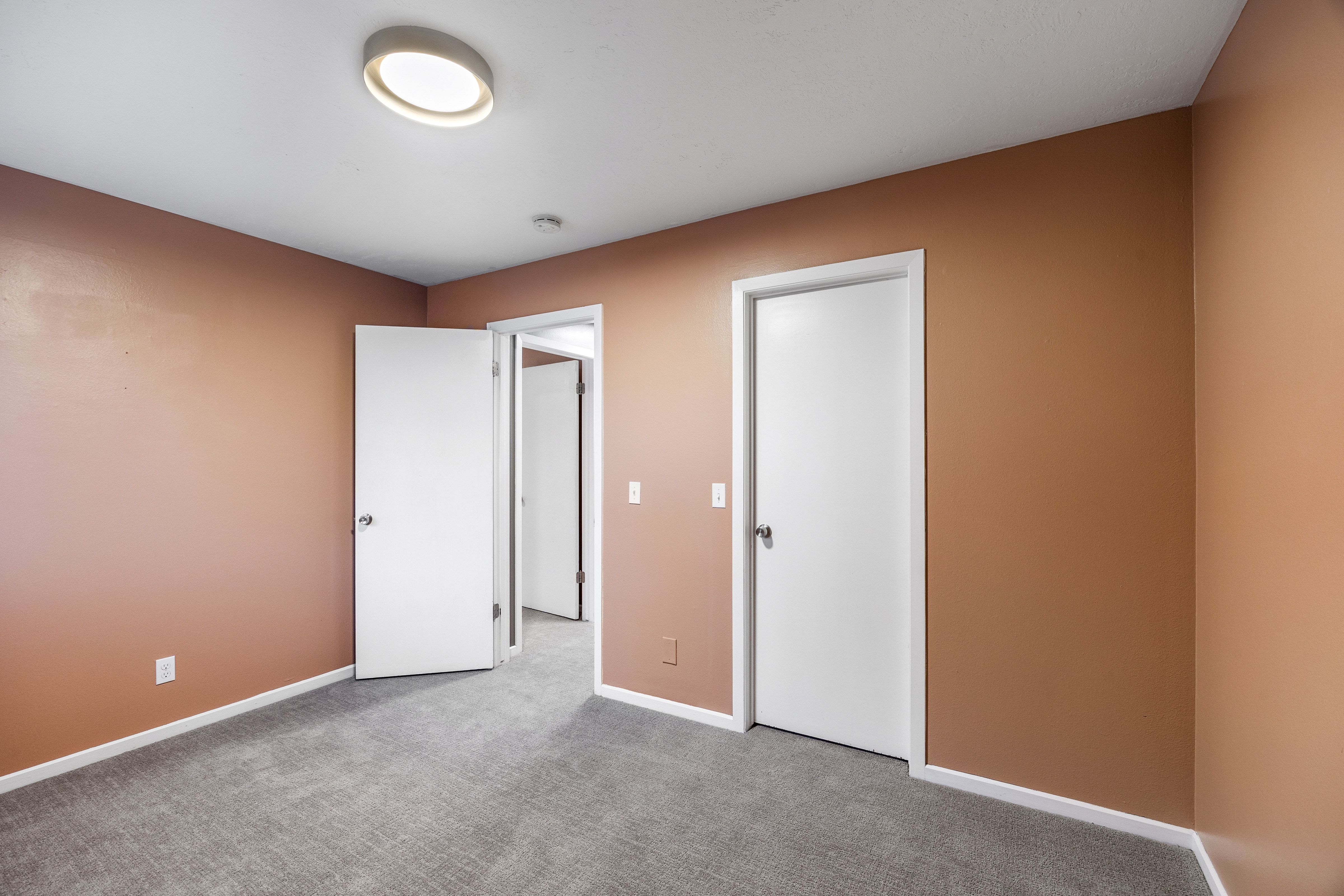 Interior room featuring light brown walls and neutral gray carpeting