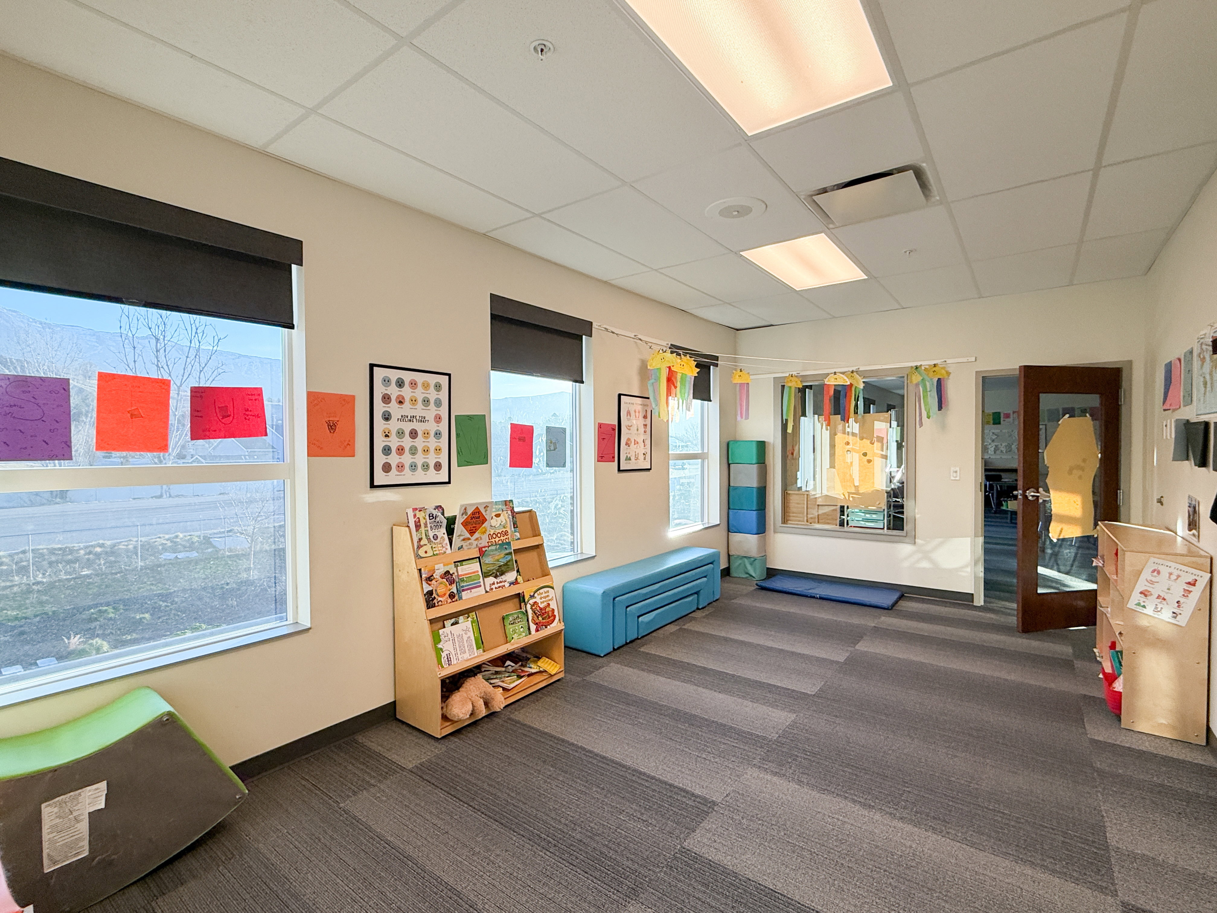 Room featuring multiple windows with roller shades, recessed lighting, and acoustic tile ceiling