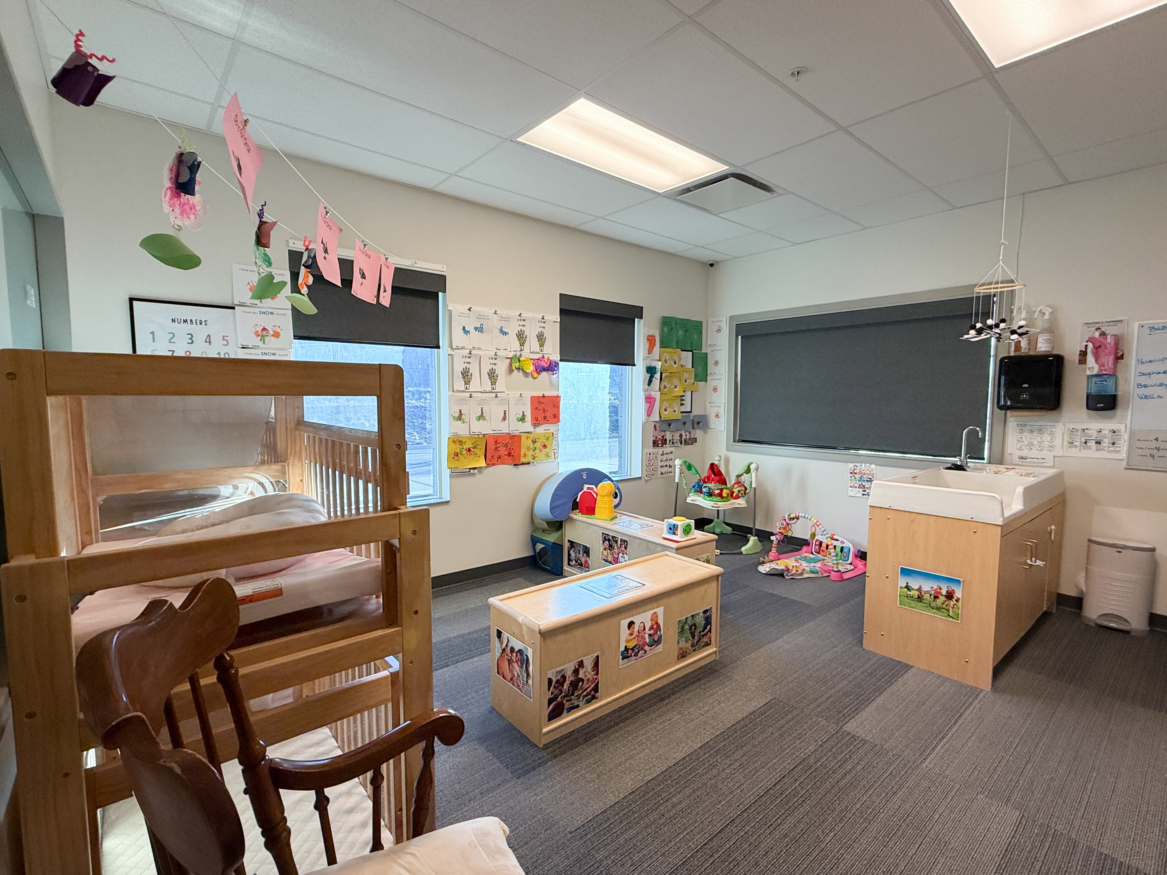 Spacious interior room featuring carpet tile flooring and multiple windows with roller shades
