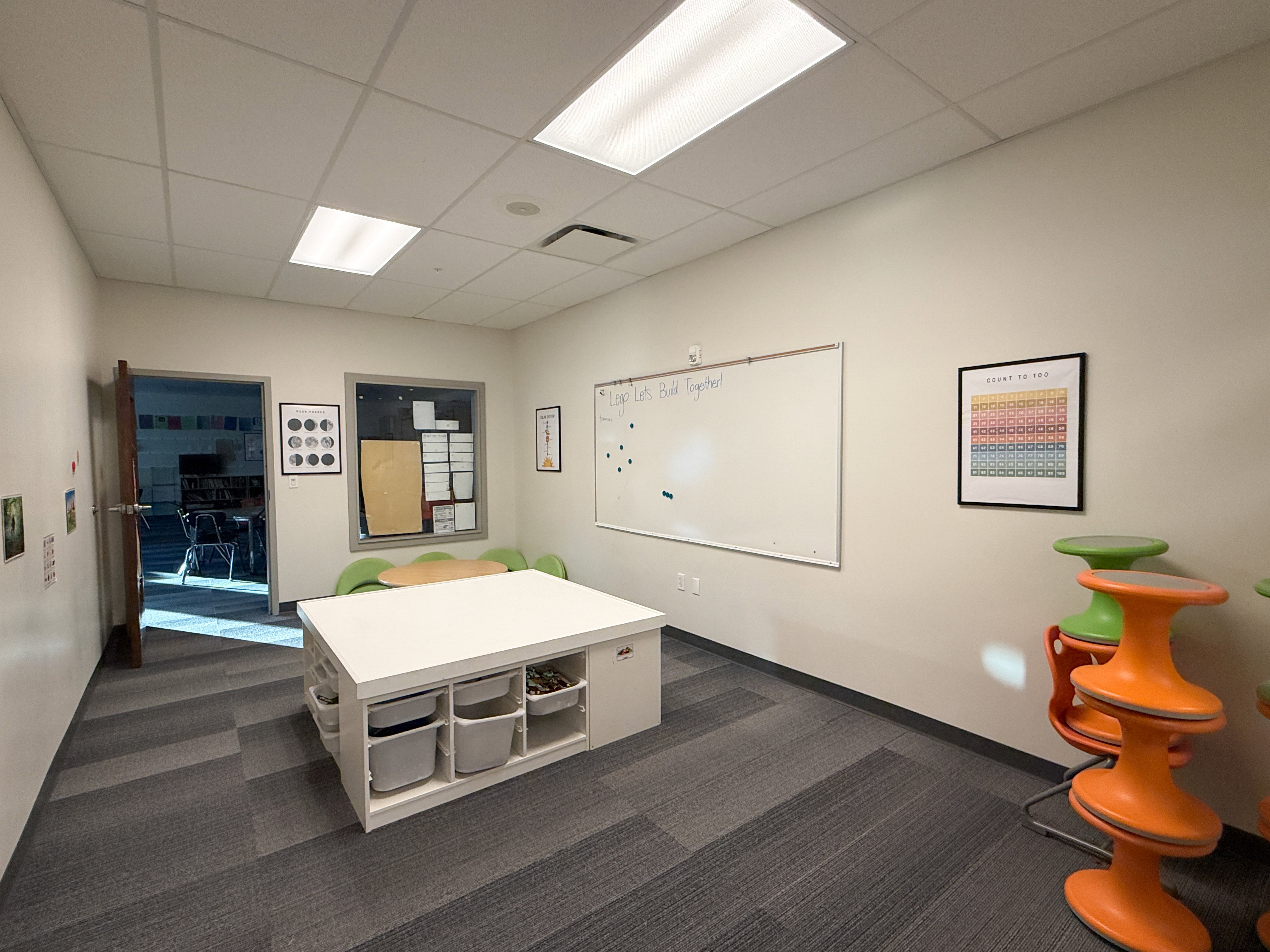 Spacious room featuring neutral wall tones and modular carpet flooring