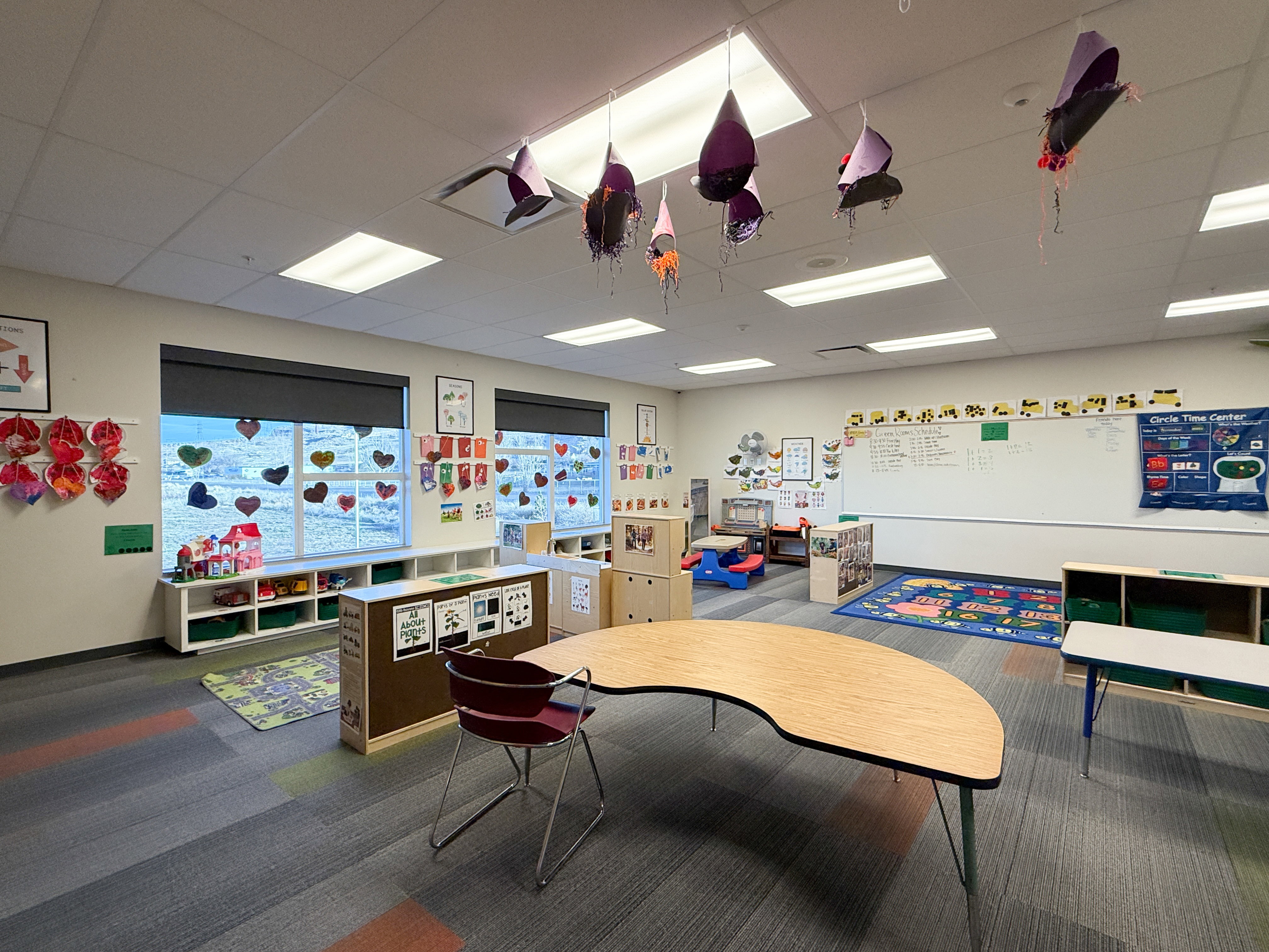 Spacious room featuring multiple large windows with roller shades, recessed lighting, and patterned carpet flooring