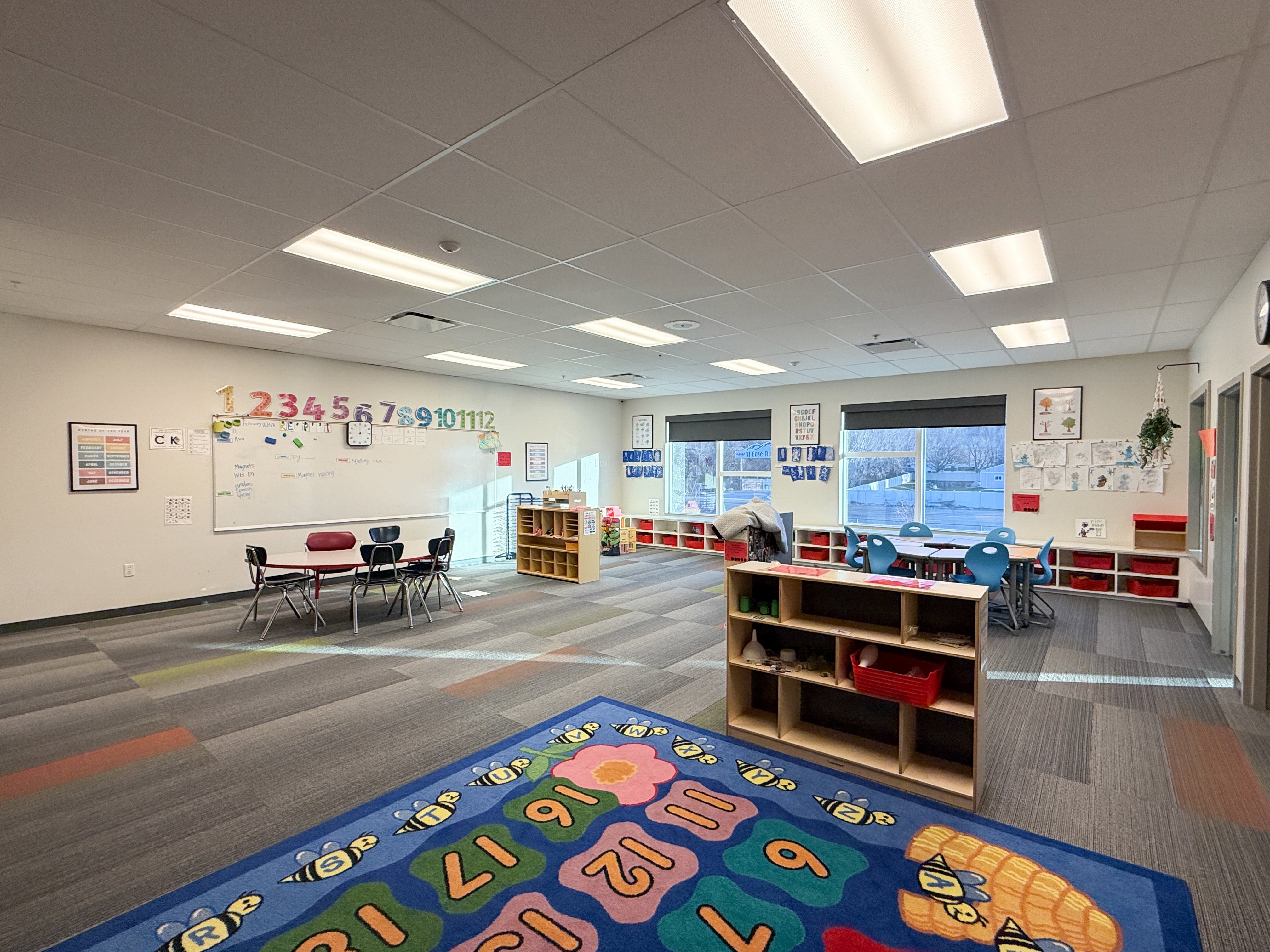 Spacious room featuring multiple large windows, recessed lighting, and patterned carpet flooring