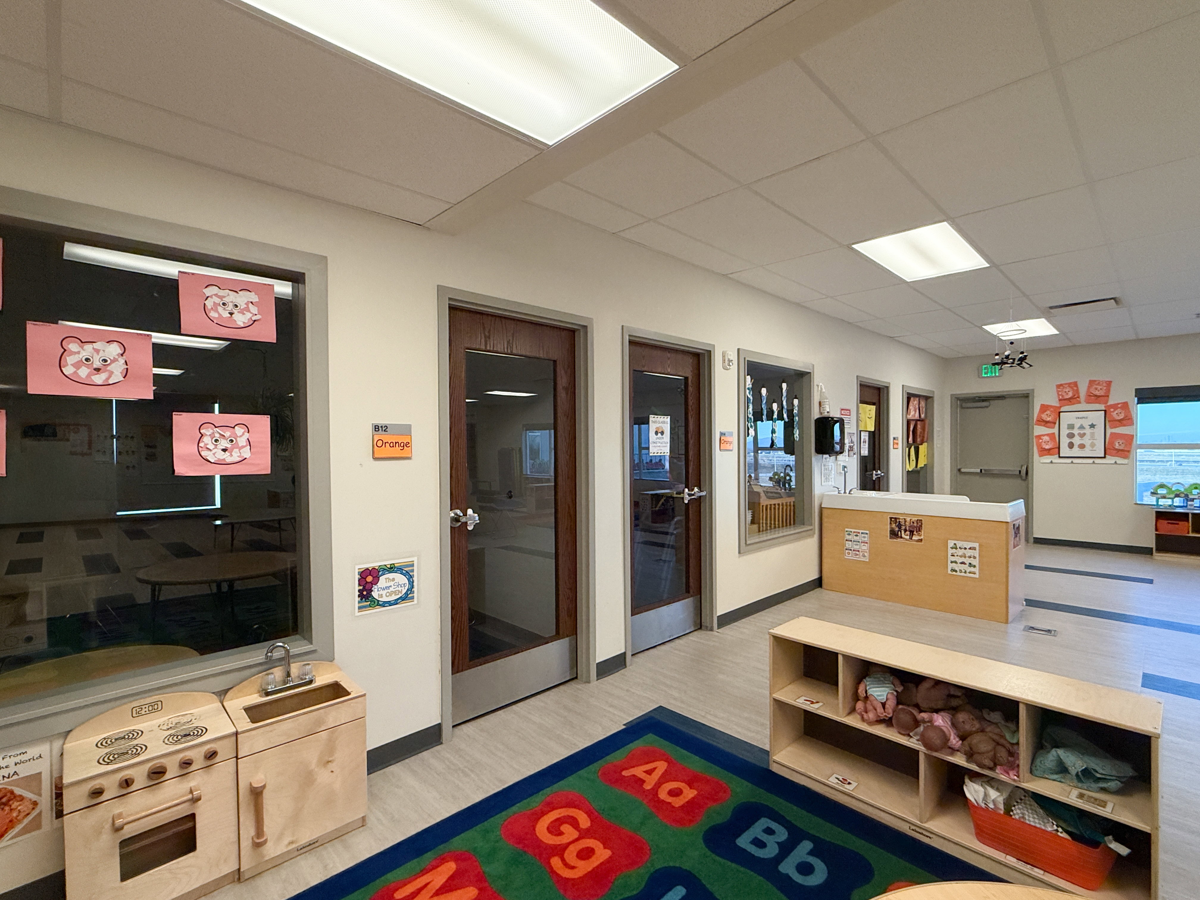 Hallway featuring light-toned flooring, recessed lighting, and multiple transparent glass panel doors