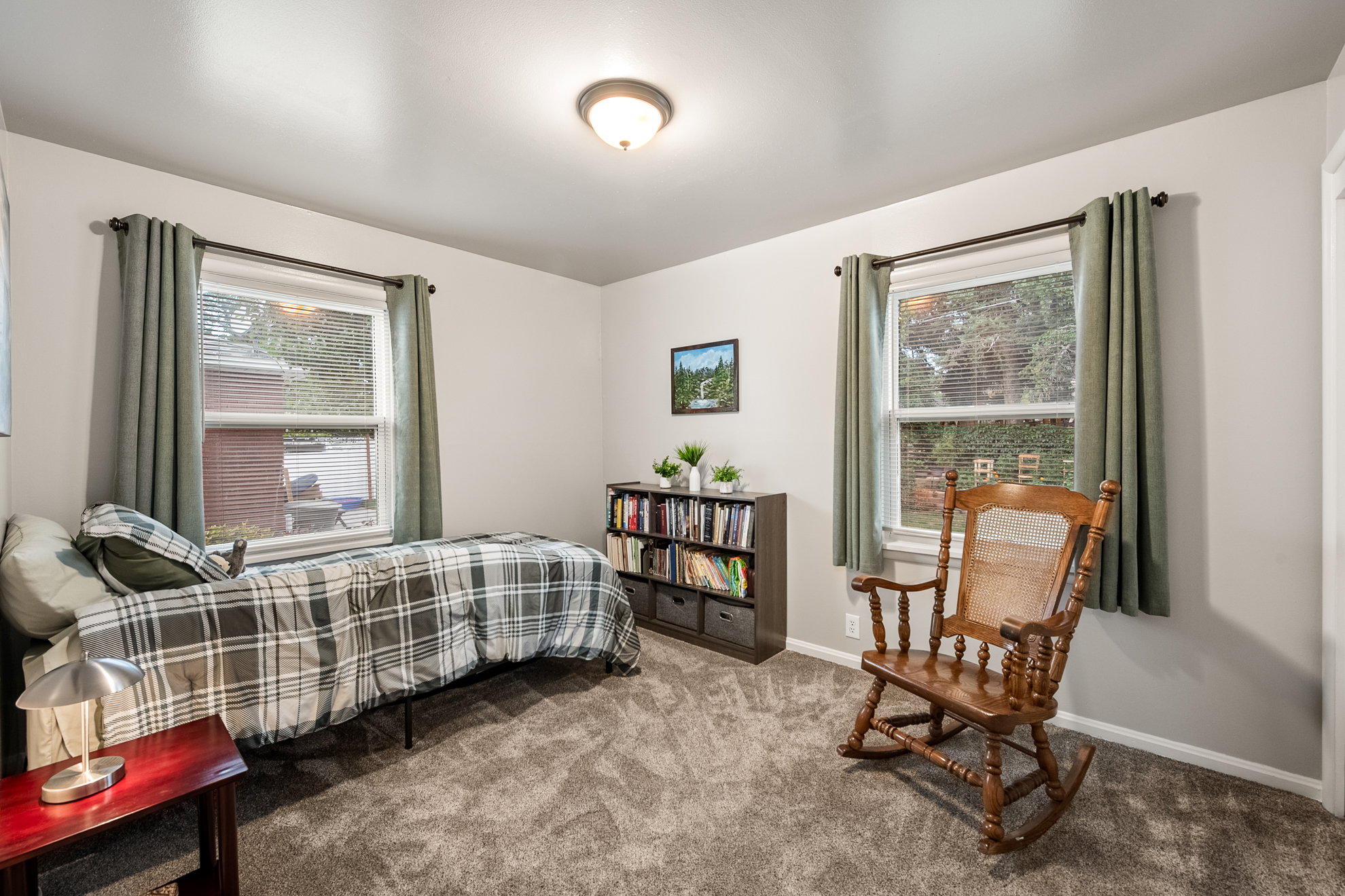 Bedroom featuring light gray walls, plush gray carpeting, and two windows with white trim